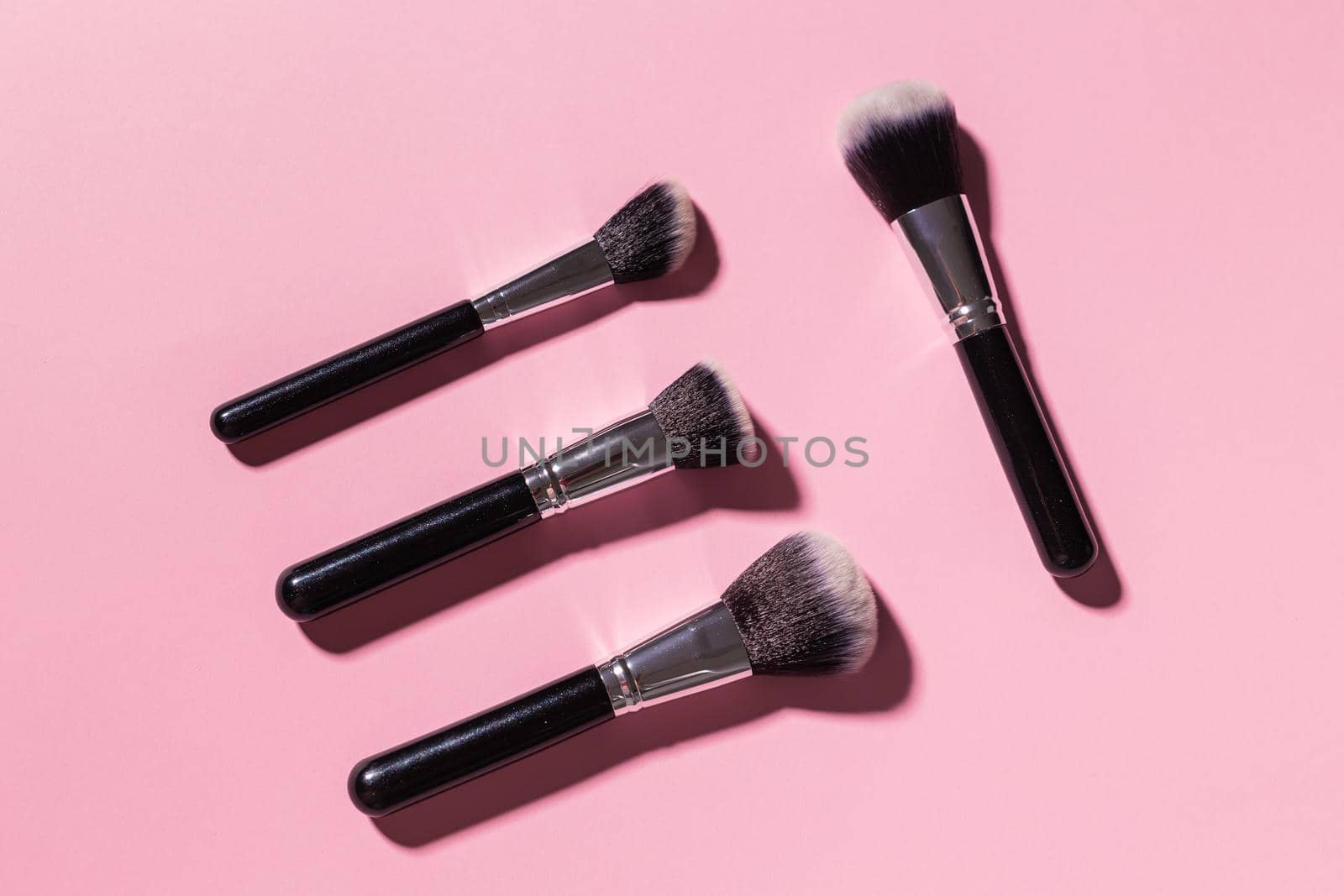 Various make-up brushes on pink background, top view. Cosmetics and beauty concept. by Satura86