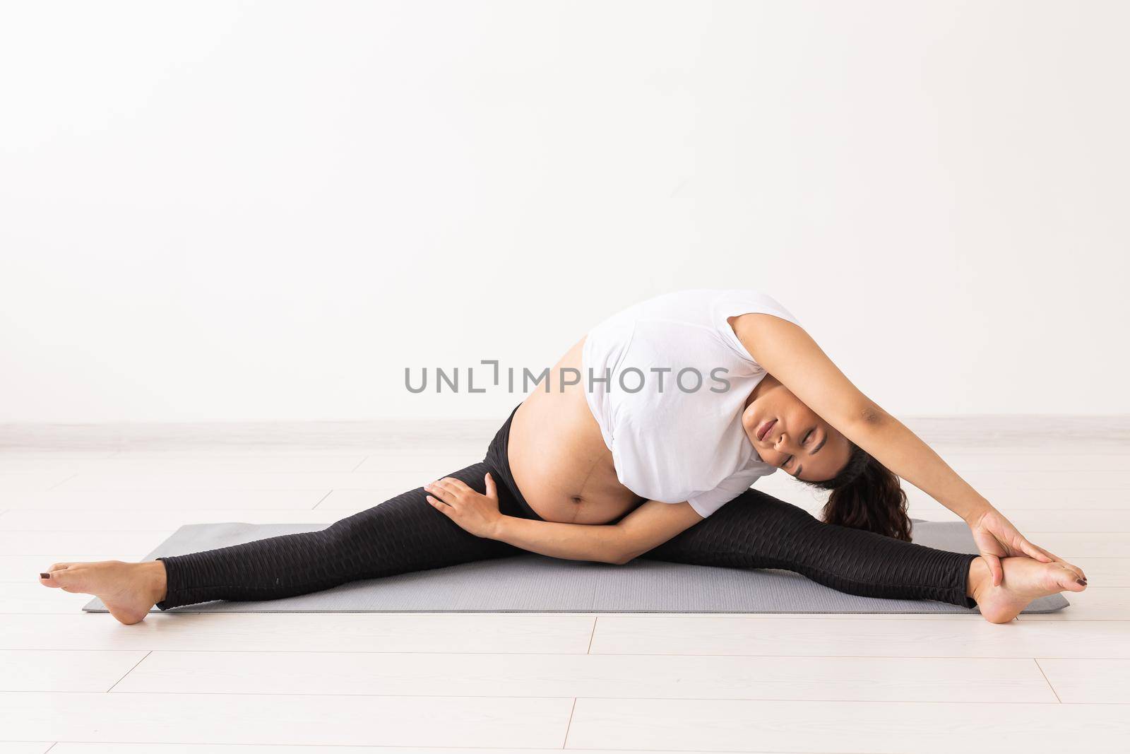 Healthy pregnant woman doing gymnastic at home. Pregnancy, healthy lifestyle and maternity leave.