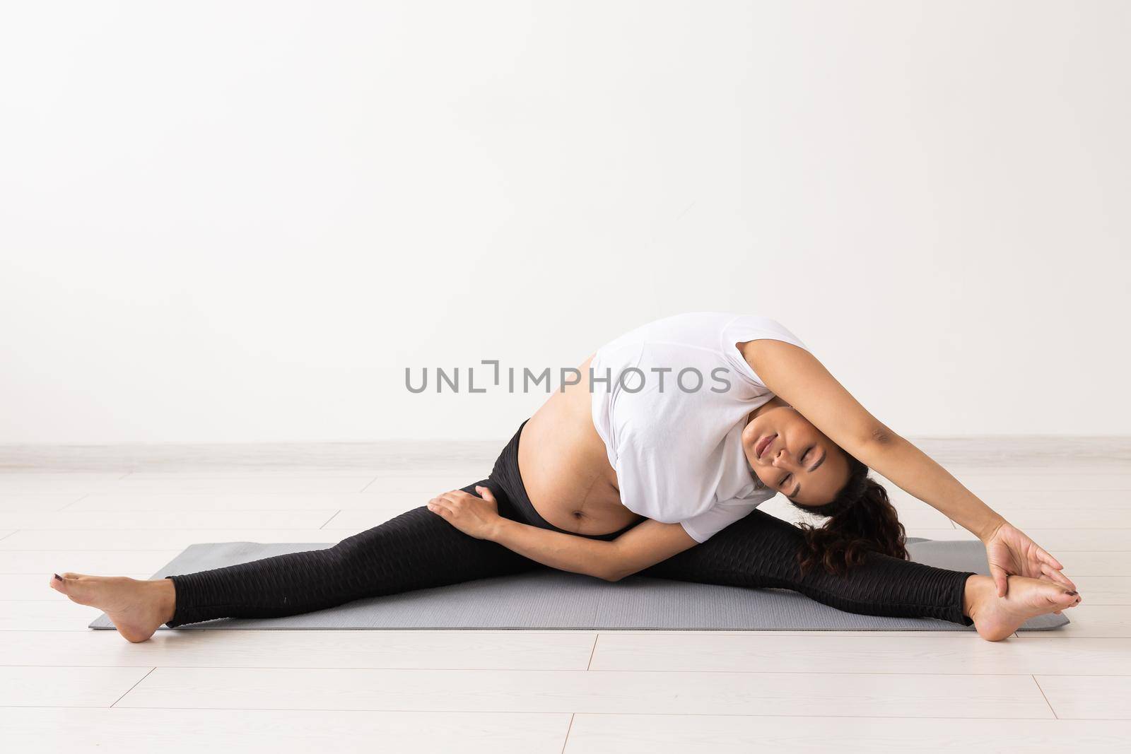 Healthy pregnant woman doing gymnastic at home. Pregnancy, healthy lifestyle and maternity leave.