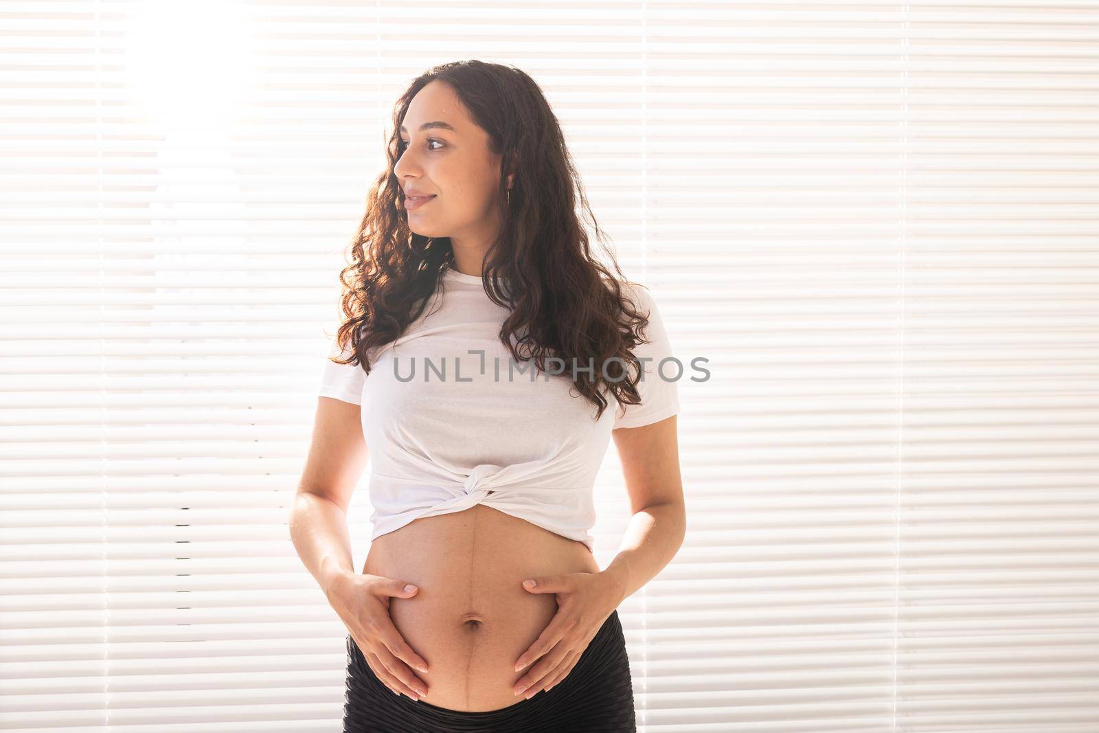 Pregnant woman touching her belly, copy space. Pregnancy and maternity leave.