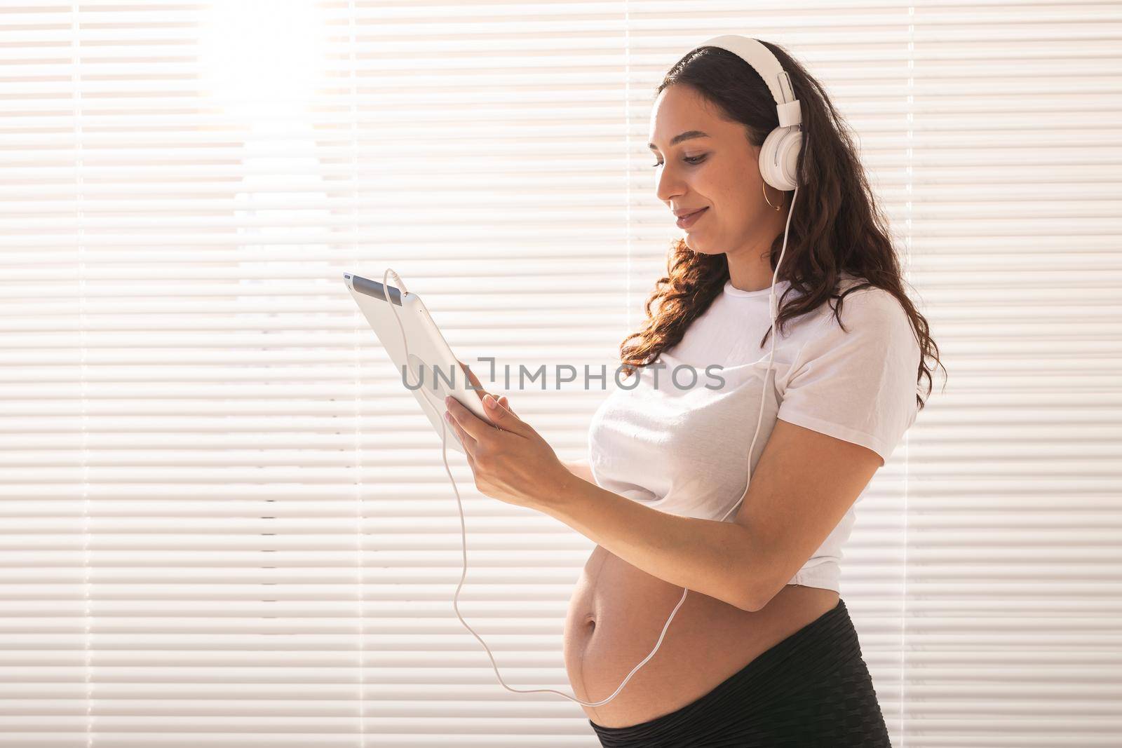 Pregnant woman listening music in headphones