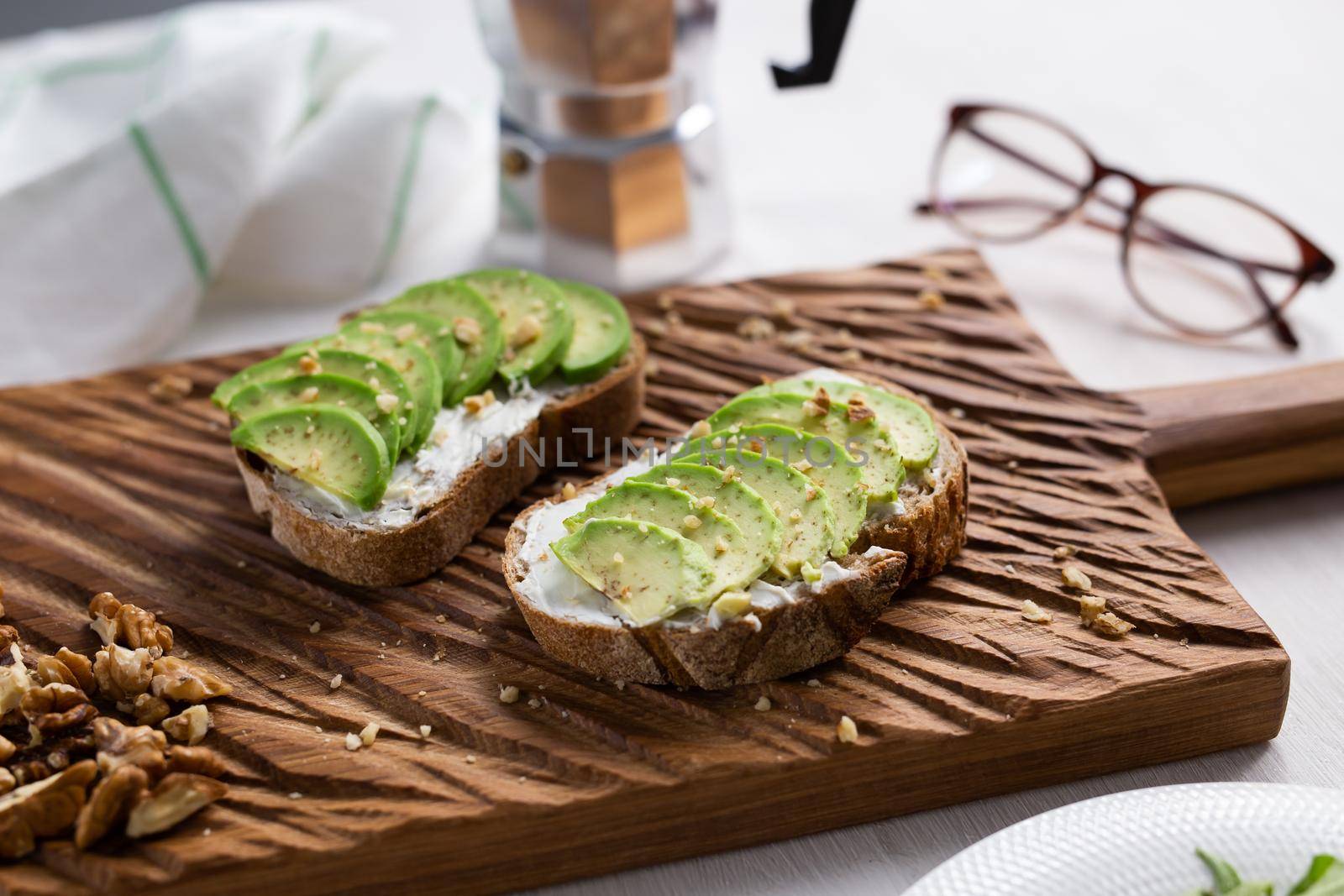 sliced avocado on toast bread with nuts by Satura86