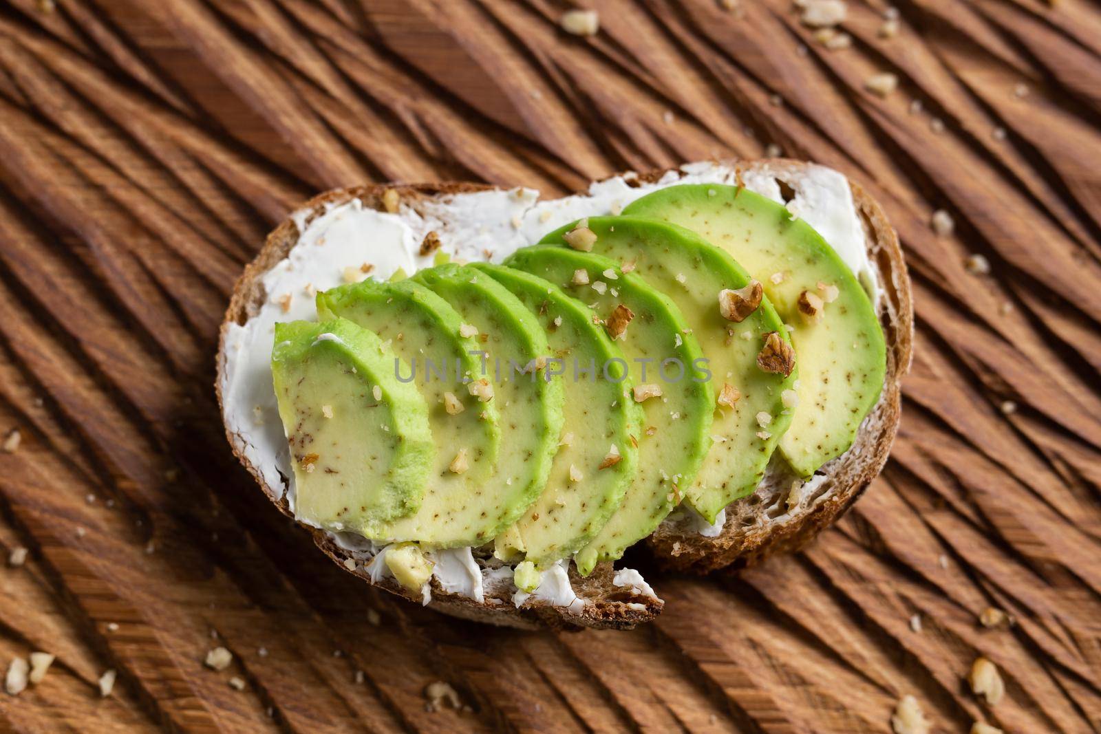 sliced avocado on toast bread with nuts by Satura86