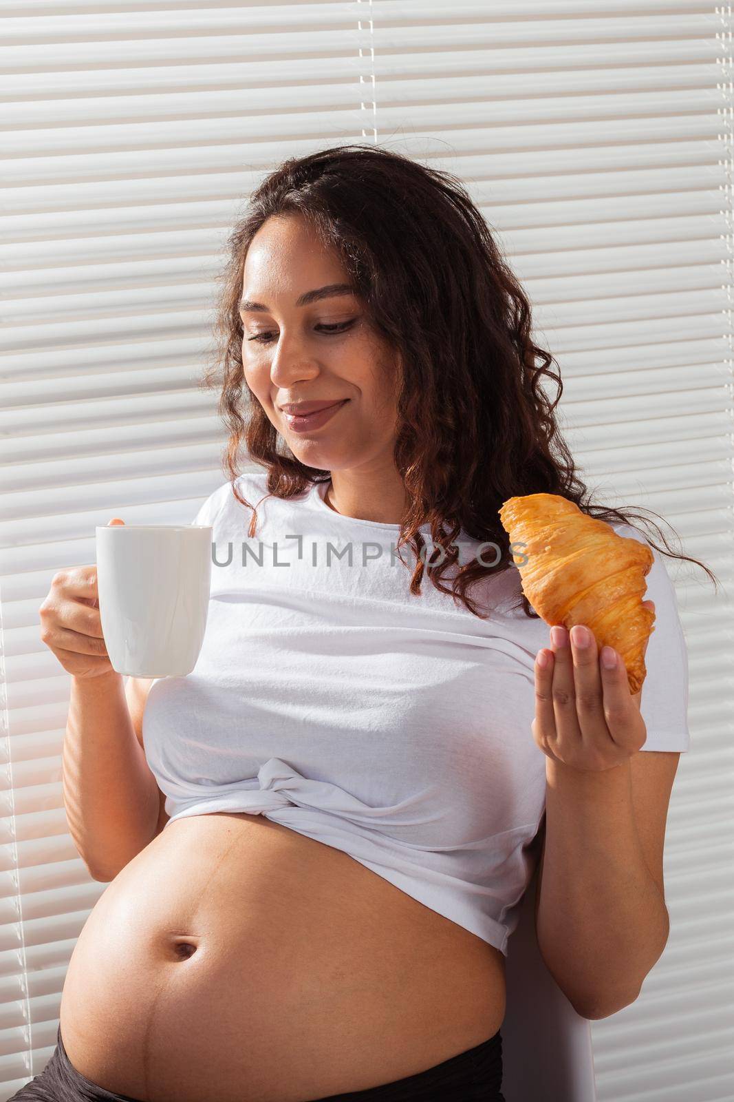 Pregnant woman eating breakfast. Pregnancy and maternity leave.