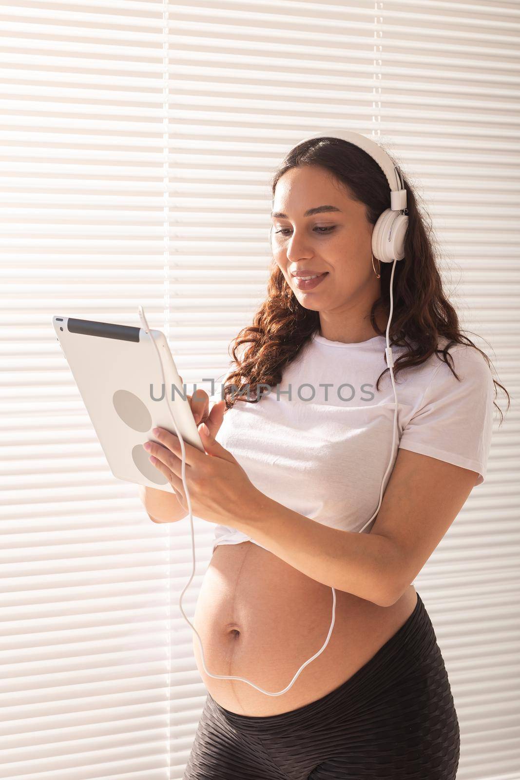 Pregnant woman using digital tablet. Technology and pregnancy