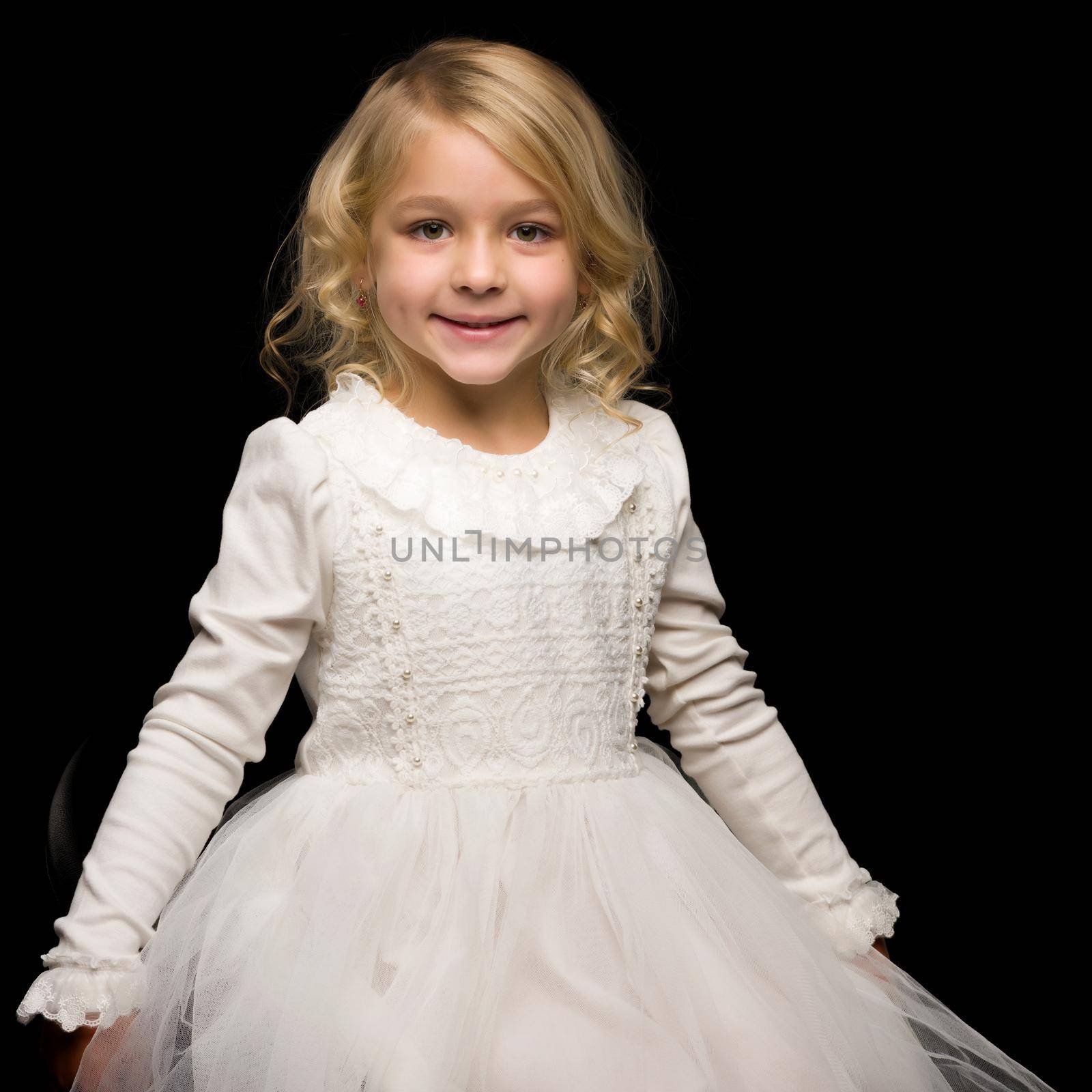 Beautiful little girl on a black background. Studio photography