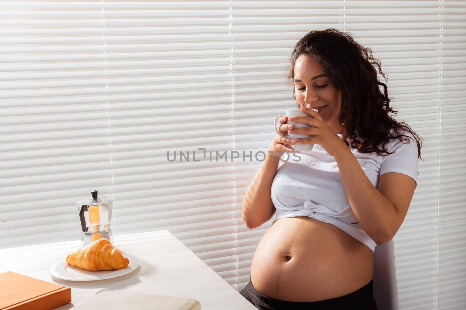 Pregnant woman eating breakfast. Pregnancy and maternity leave.