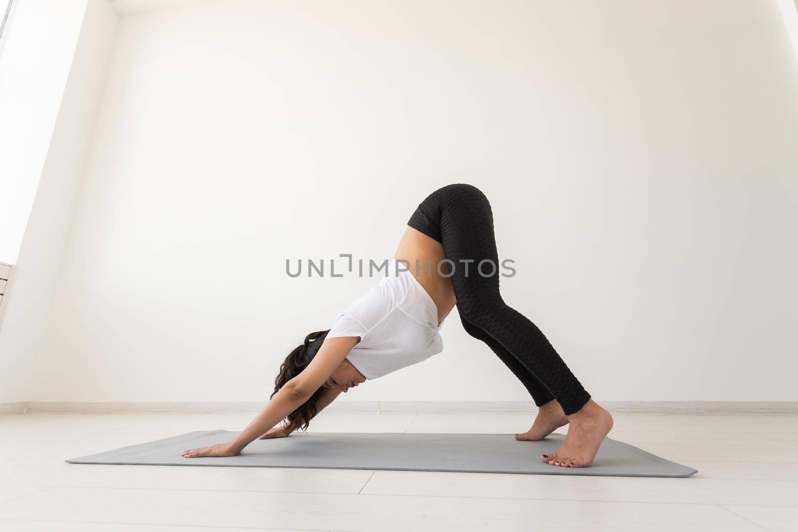 Purposeful pregnant woman exercises during yoga class and relaxes while sitting on a mat on the floor. Physical and mental preparation of the body for childbirth. Place for text