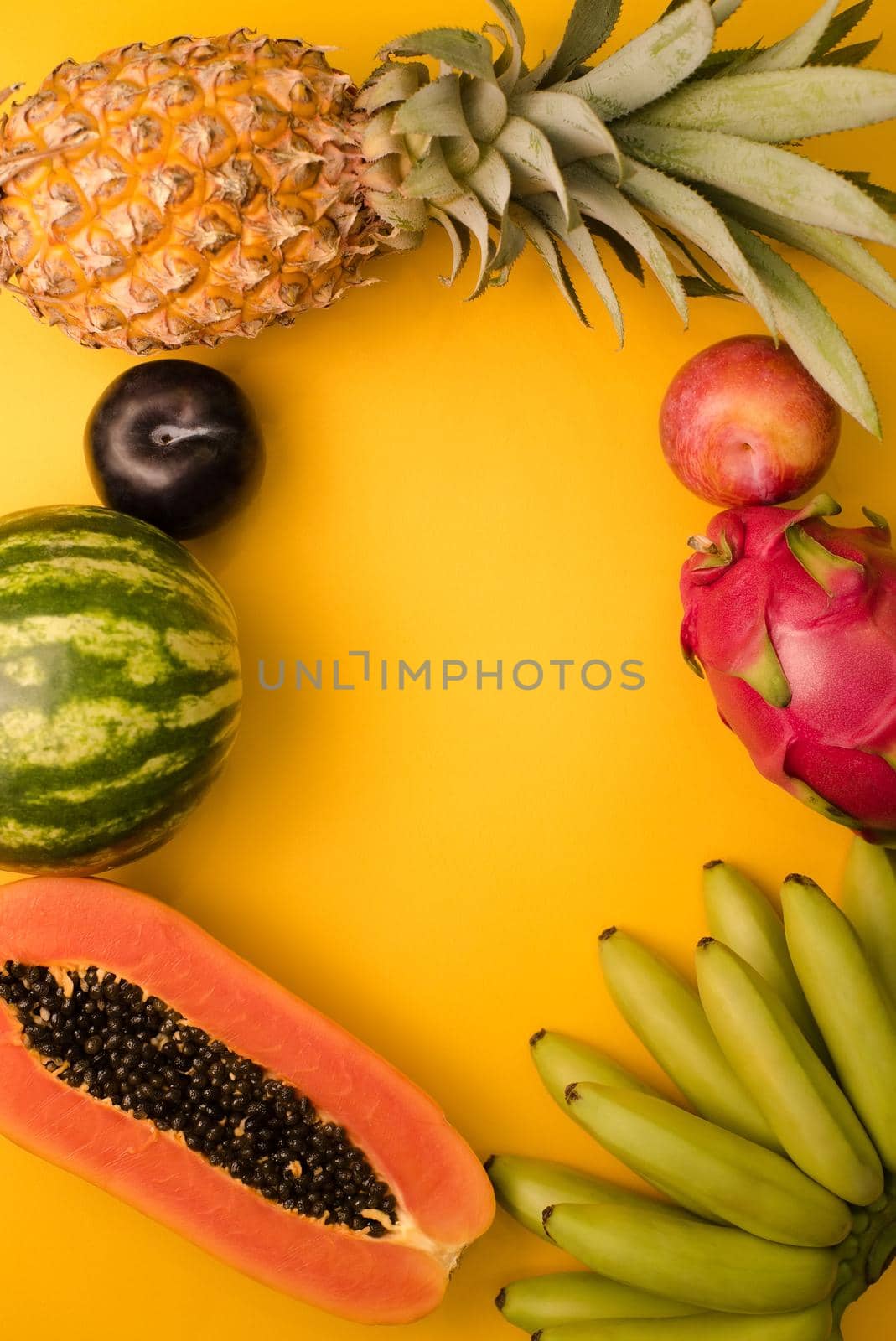 Fruits cut on a bright yellow background with a place for writing