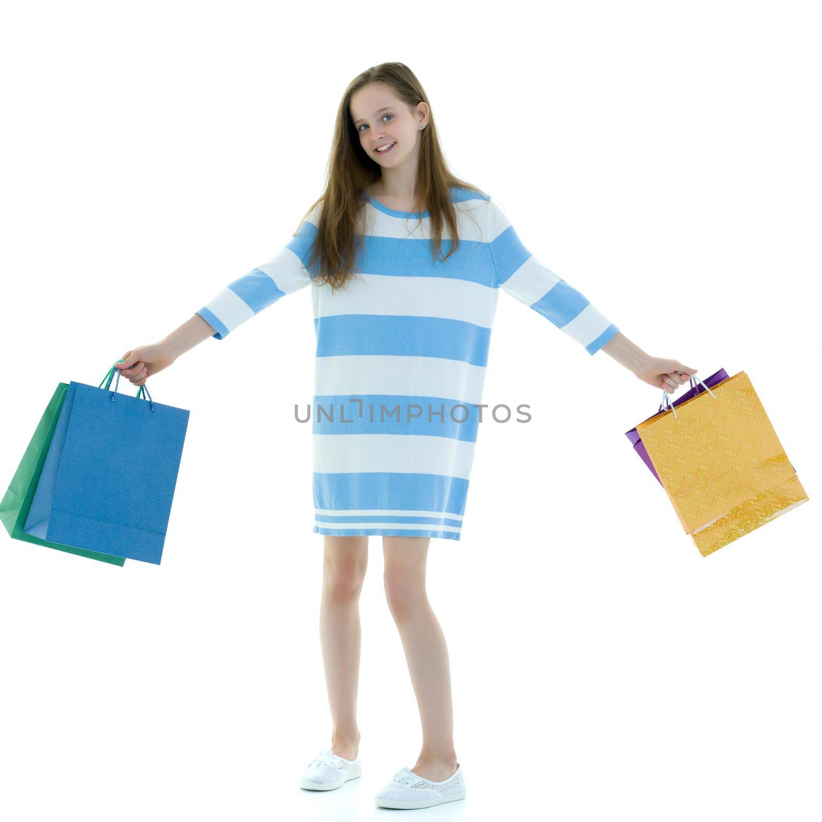 Beautiful teen girl shopping in a store. With large paper bags in hand. The concept of holiday sales, advertising products. Isolated on white background.