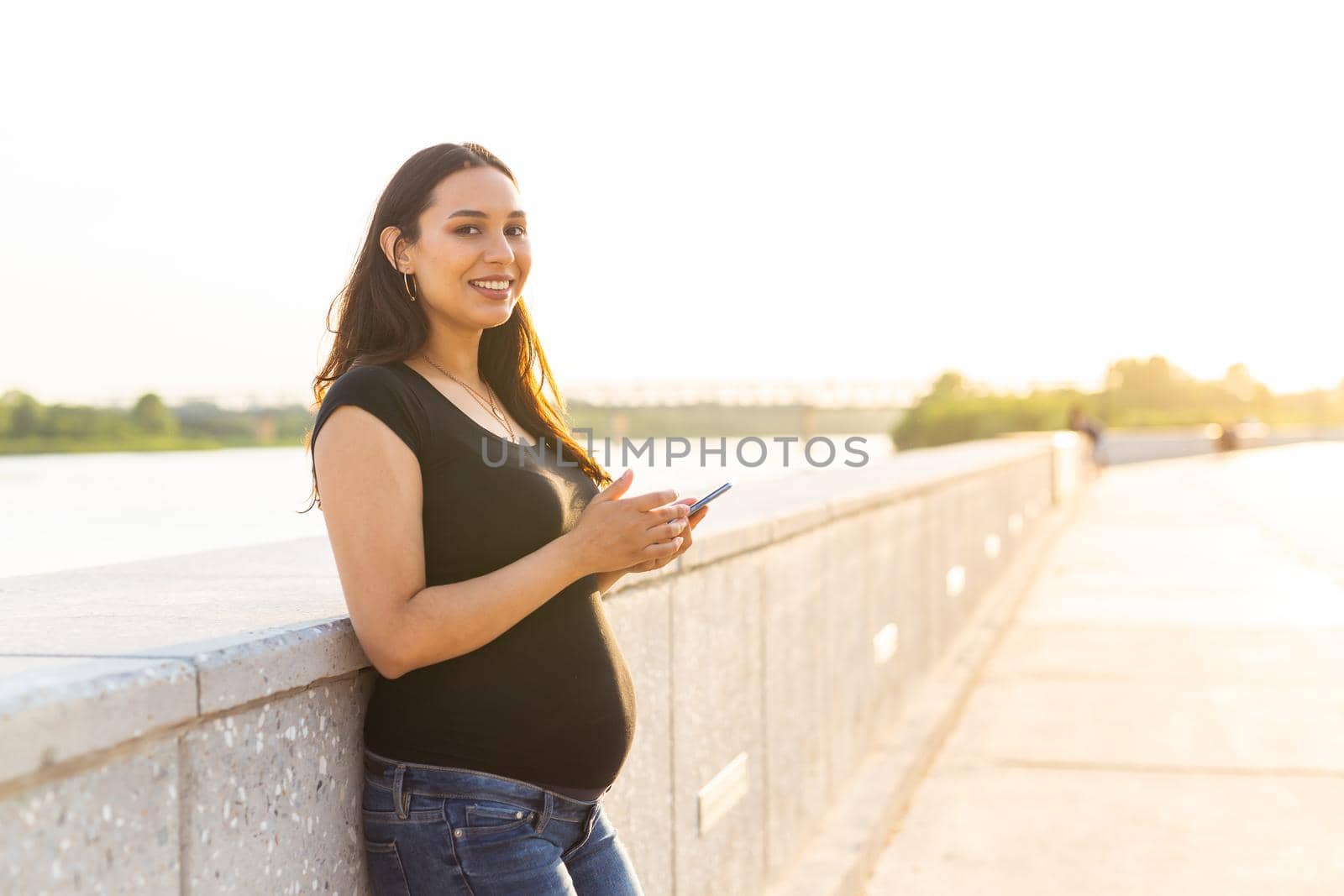 Pregnant woman with smartphone outdoors. Pregnancy, technology and communication concept by Satura86