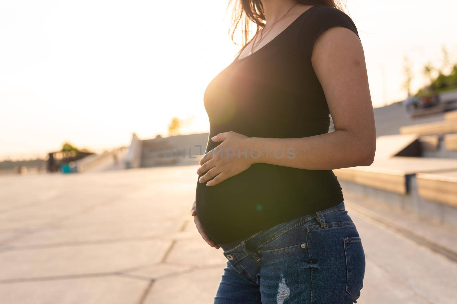 Close-up of pregnant belly outdoors. Pregnancy and motherhood