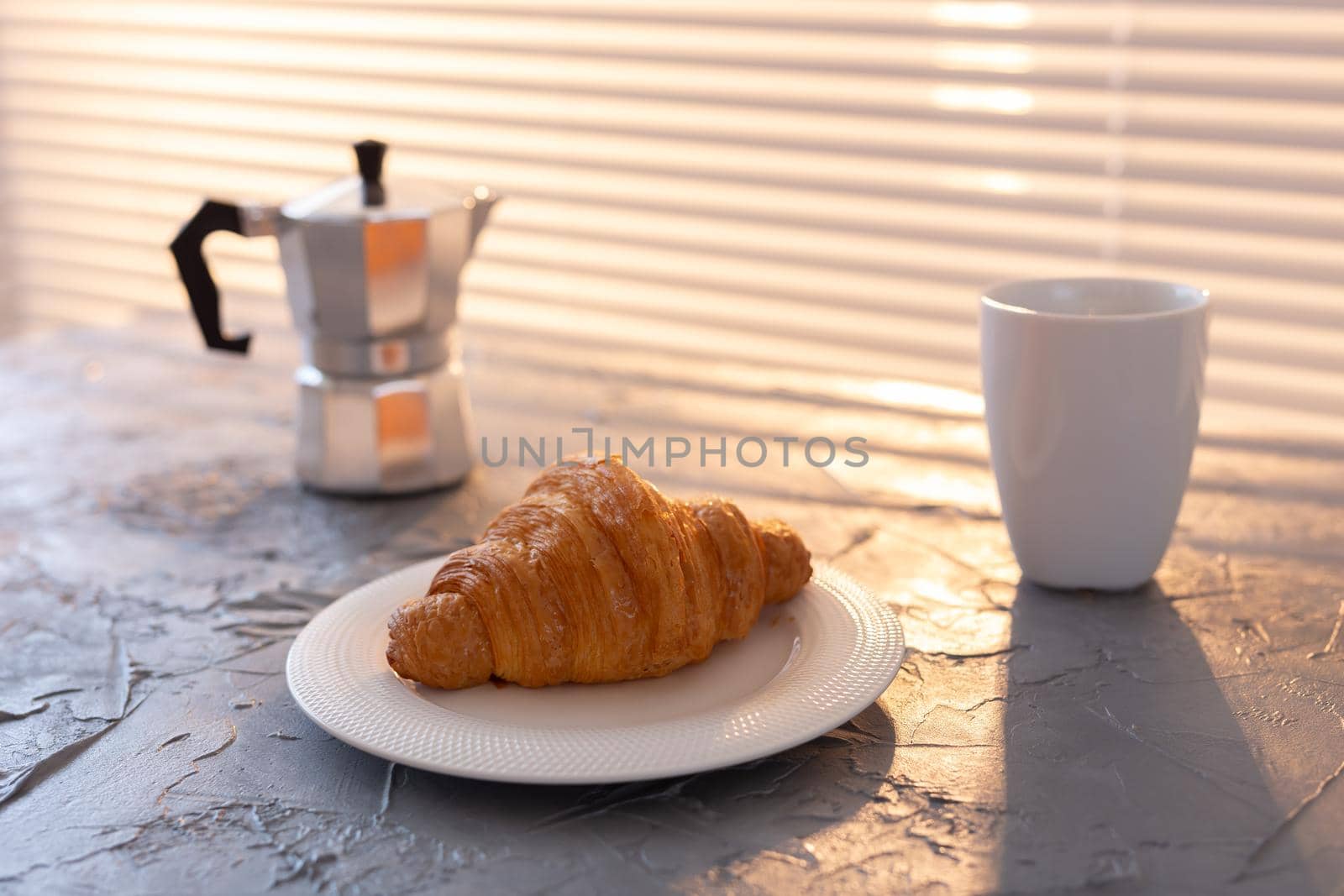 Breakfast with croissant on cutting board and black coffee. Morning meal and breakfast.