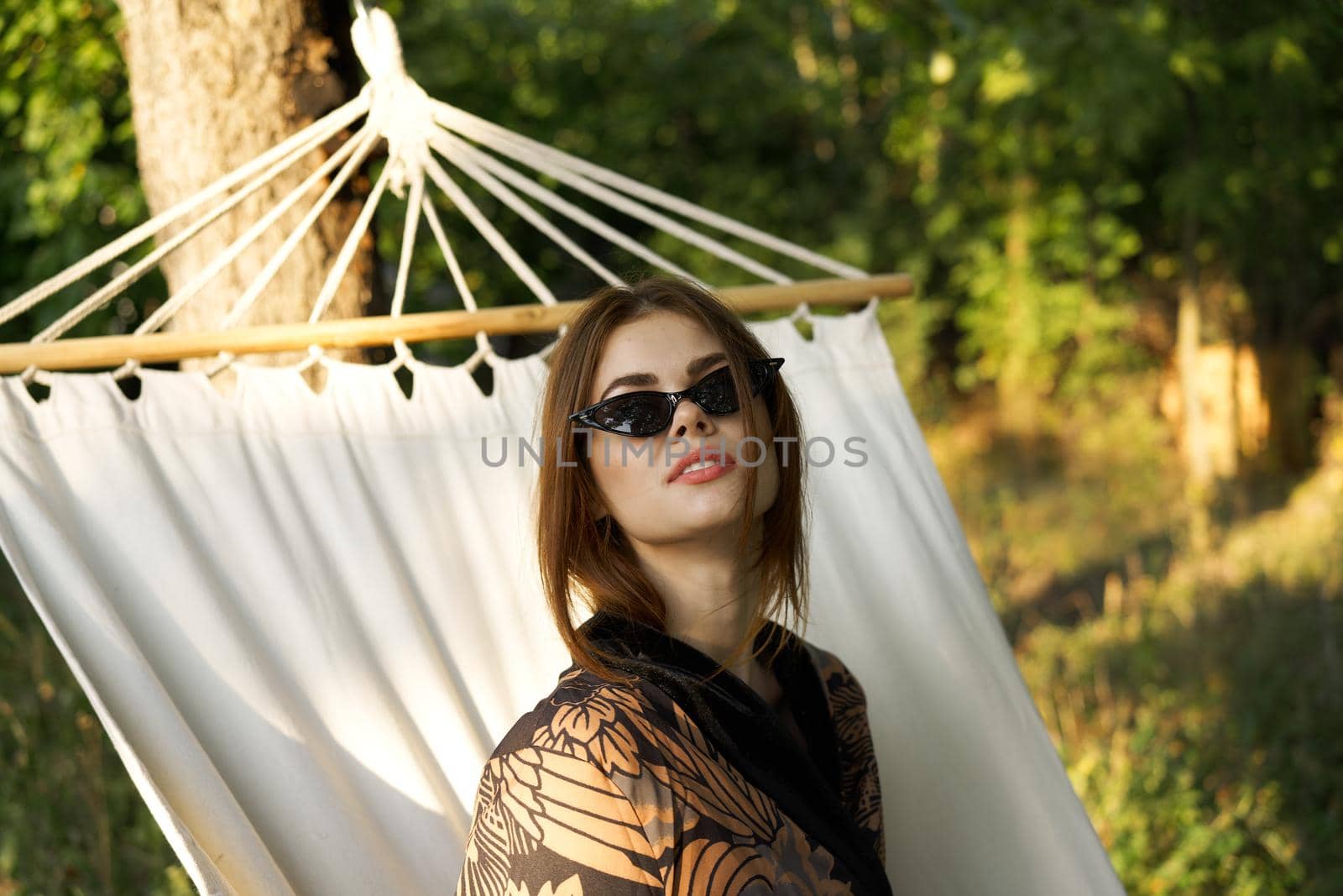 woman in sunglasses lies in a hammock outdoors summer lifestyle. High quality photo