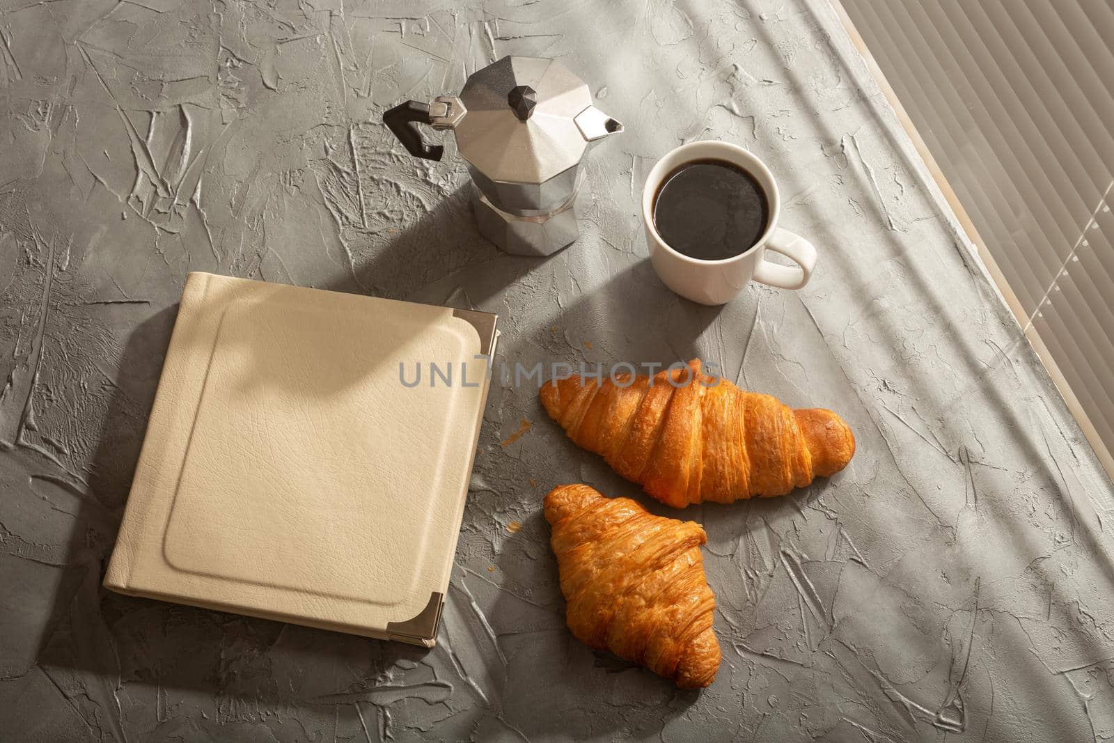 Still life for pleasant morning coffee turk cup and croissants with book on the table. Lunch break concept or start the morning by Satura86