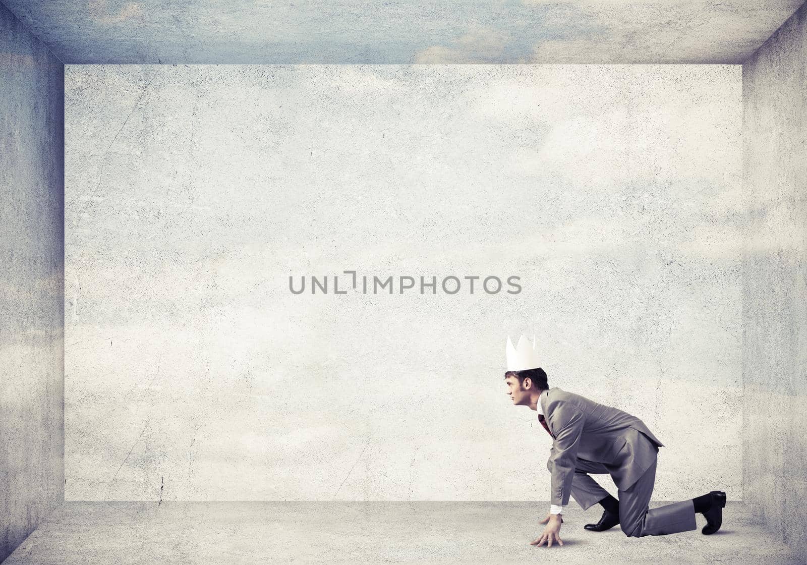 Young handsome businessman wearing white paper crown running in a hurry