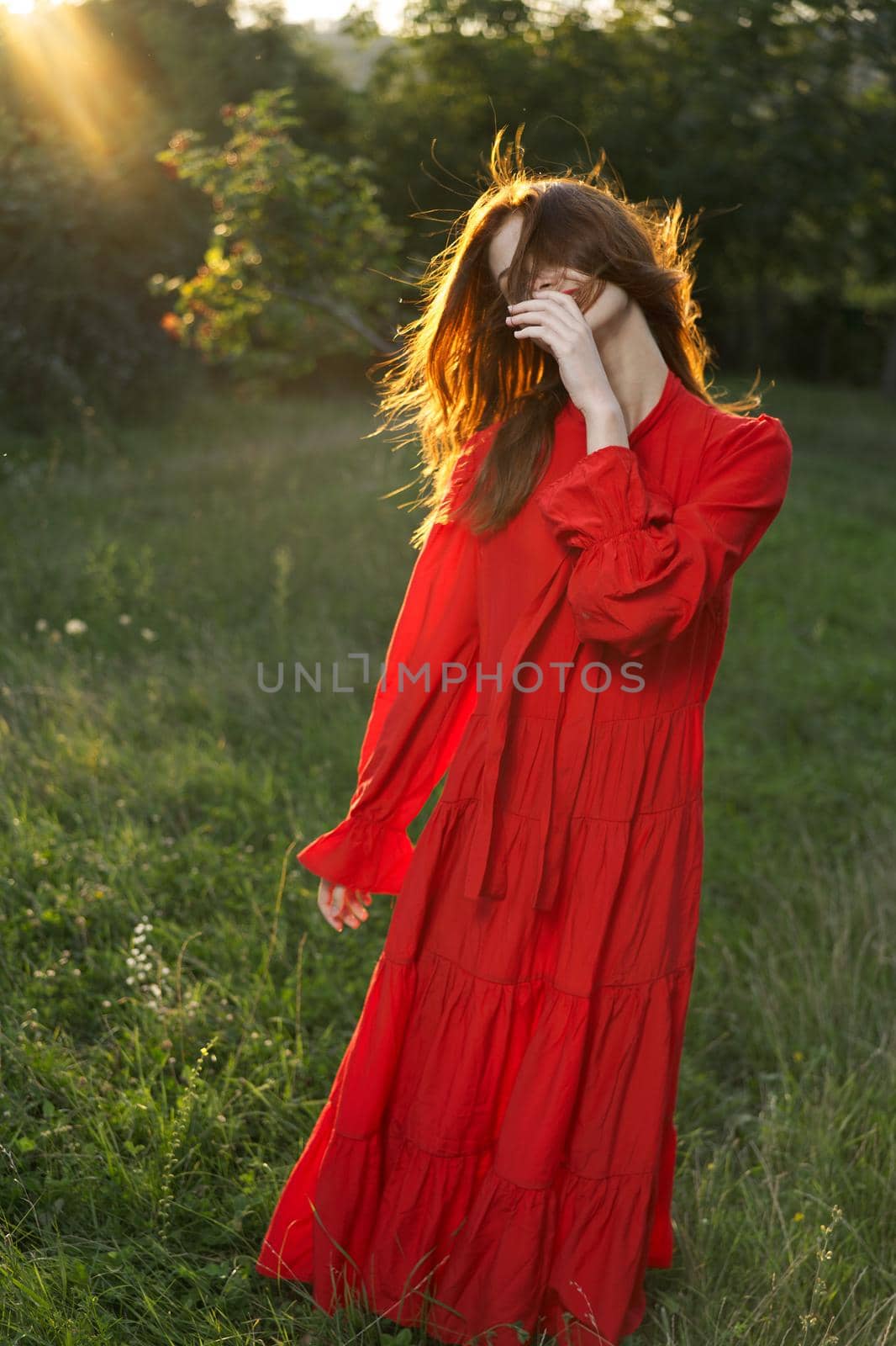 woman in red dress posing nature sun fun. High quality photo