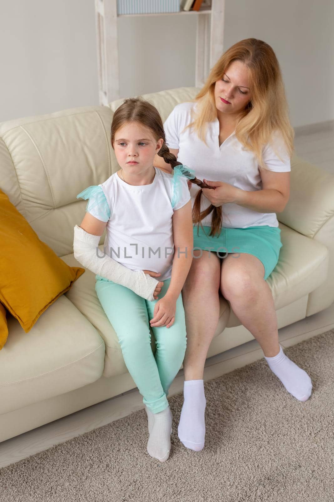 Child with broken arm and gypsum spend time at home with mother. Childhood illnesses, a positive outlook and recovery. by Satura86