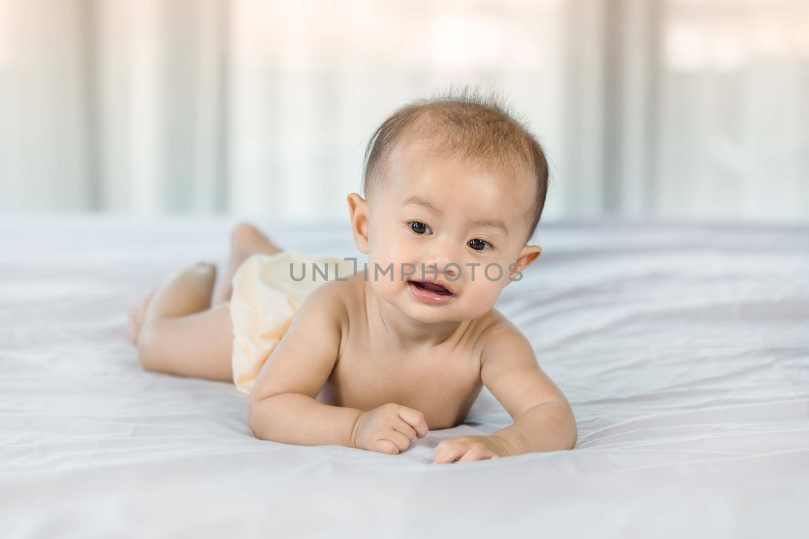 portrait of baby on a bed in bedroom at home