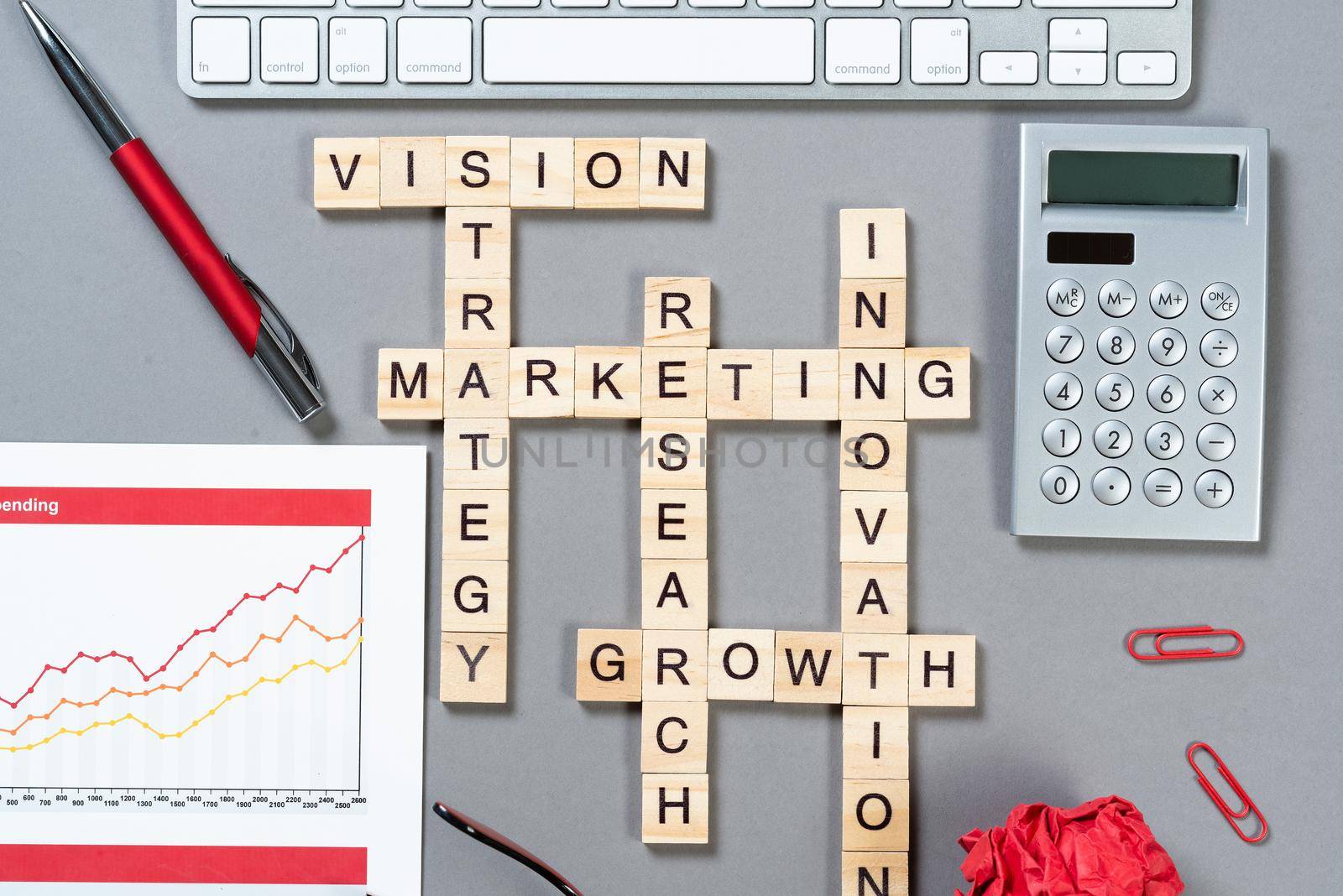 Business motivation concept with words from cubes. Still life of office workplace with crossword. Flat lay grey surface with computer keyboard and calculator. Strategy planning and business analytics