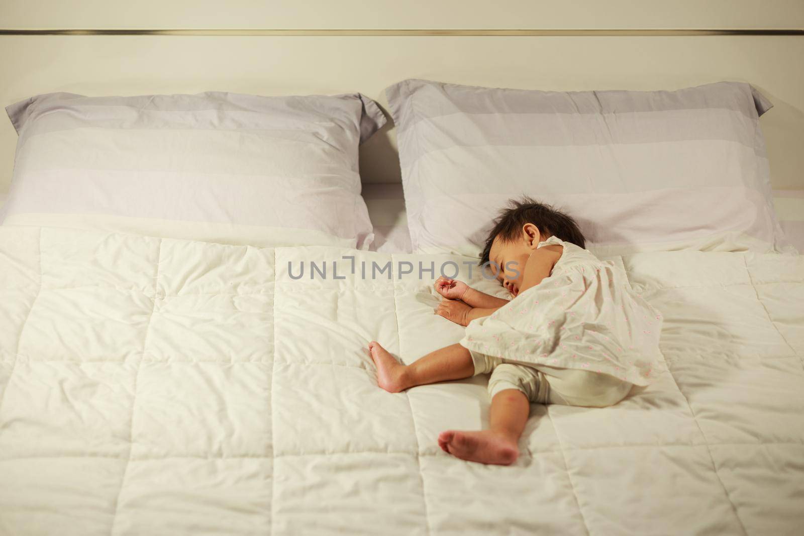 baby sleeping on bed in bedroom at home