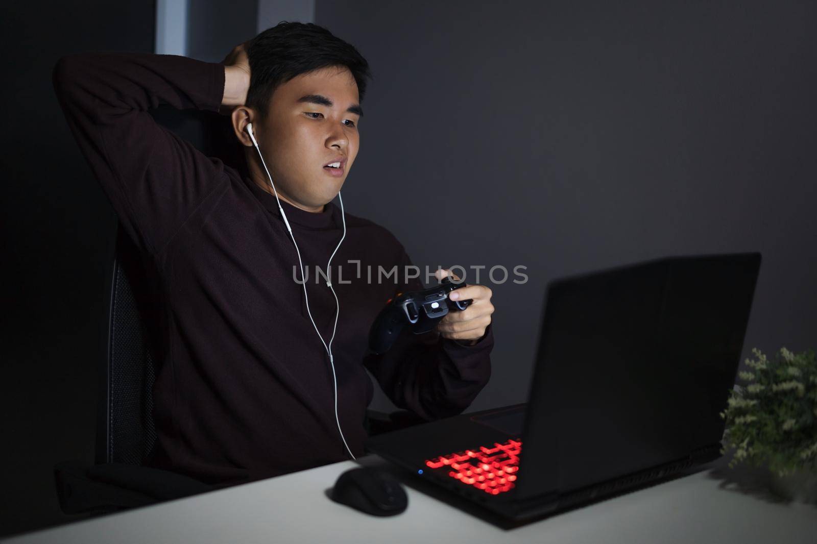 Stressed depressed young man using joystick to playing games