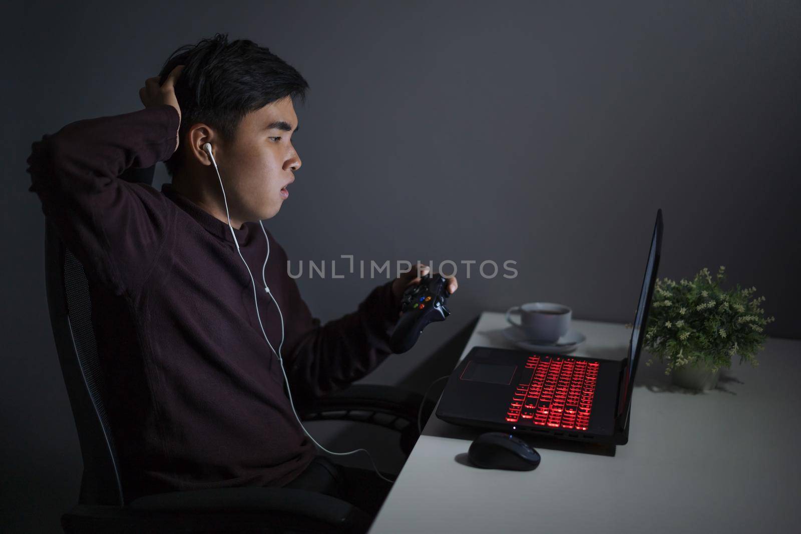 Stressed depressed young man using joystick to playing games