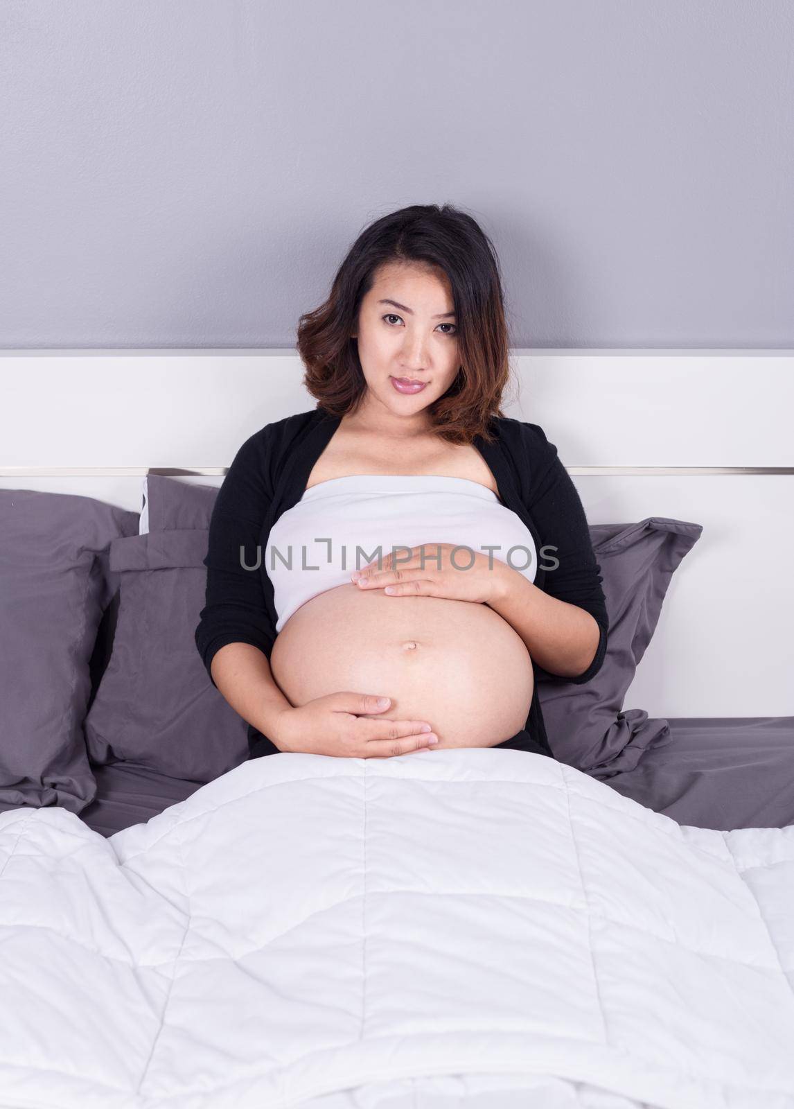 pregnant woman lying on bed in the bedroom at home