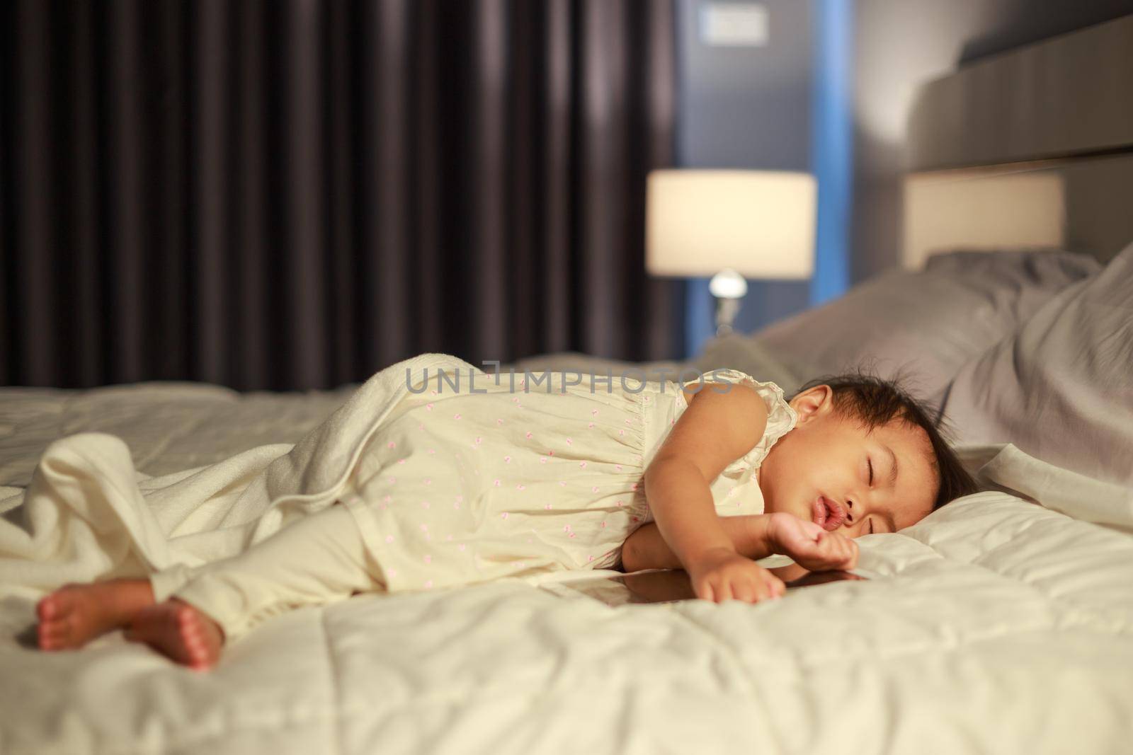 baby sleeping on bed after playing tablet by geargodz