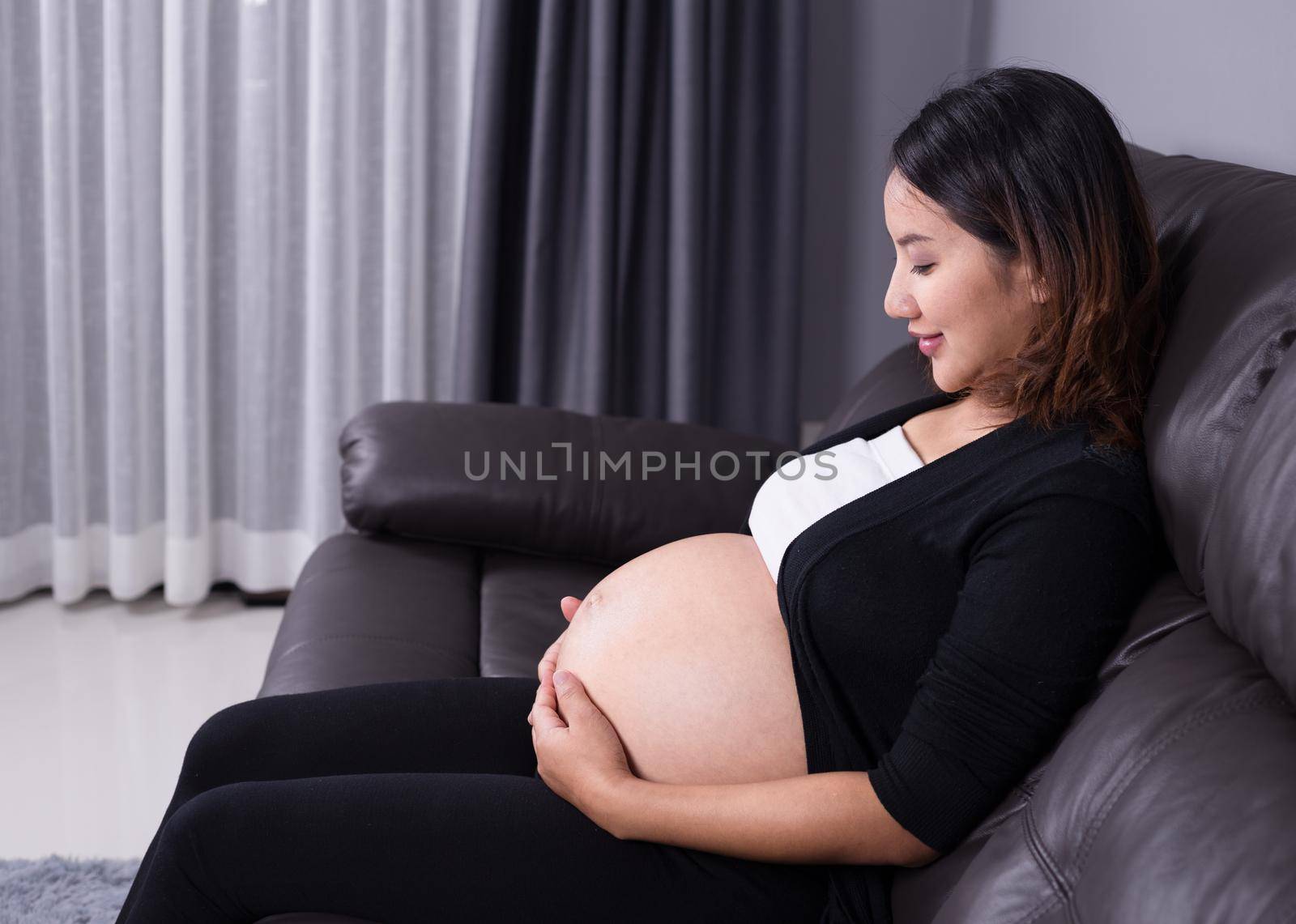 portrait of pregnant woman resting at home on sofa