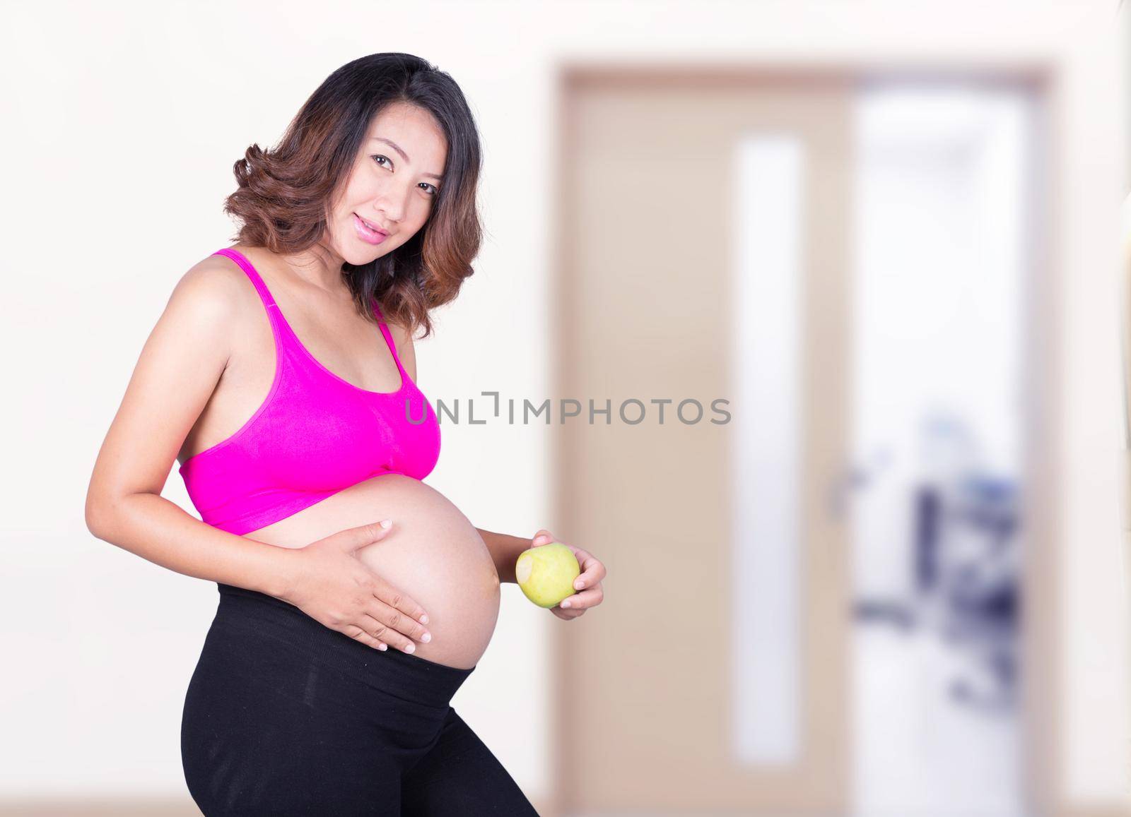 Beautiful pregnant woman with green apple in hospital by geargodz