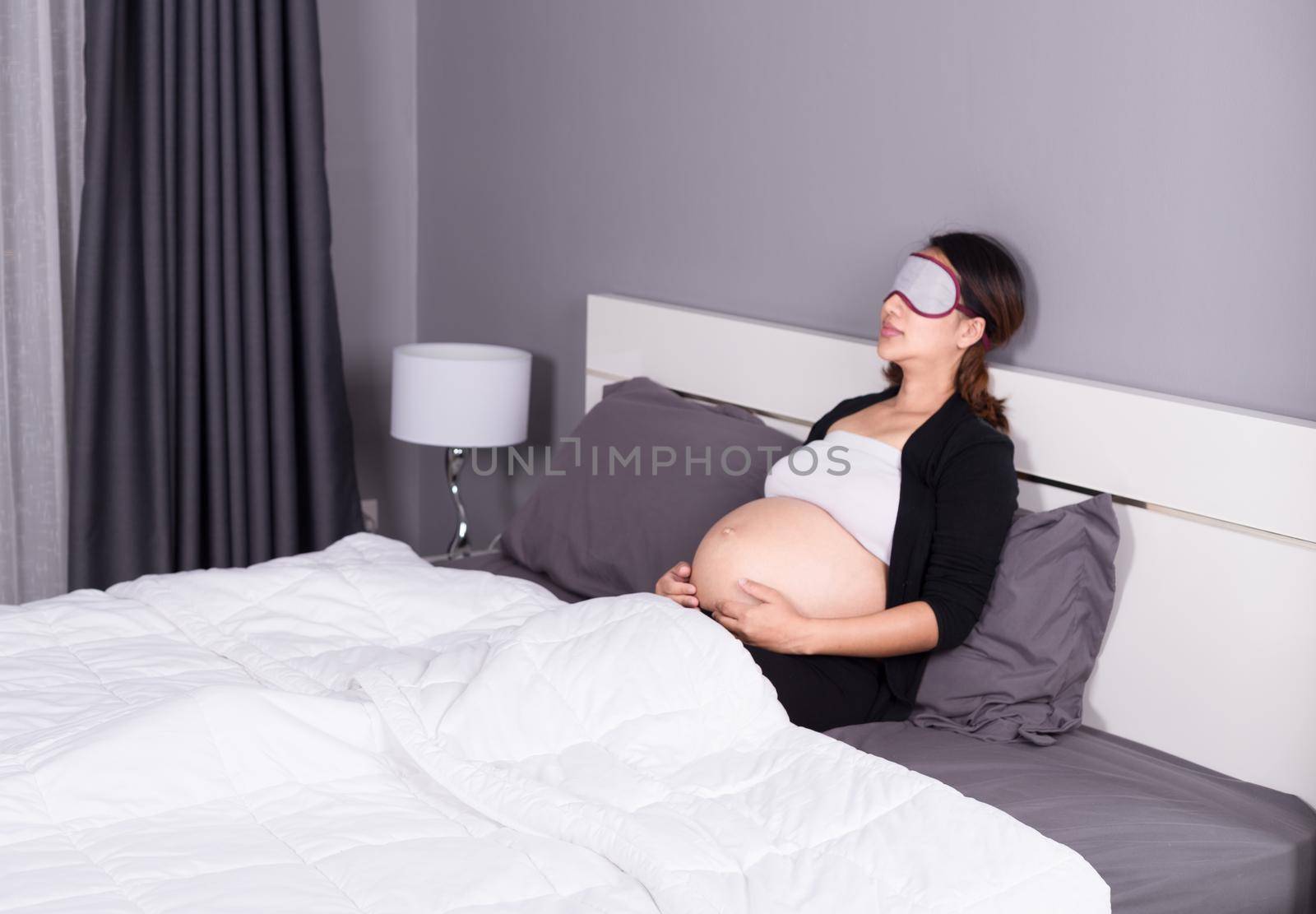 pregnant woman sleeping on bed in the bedroom by geargodz