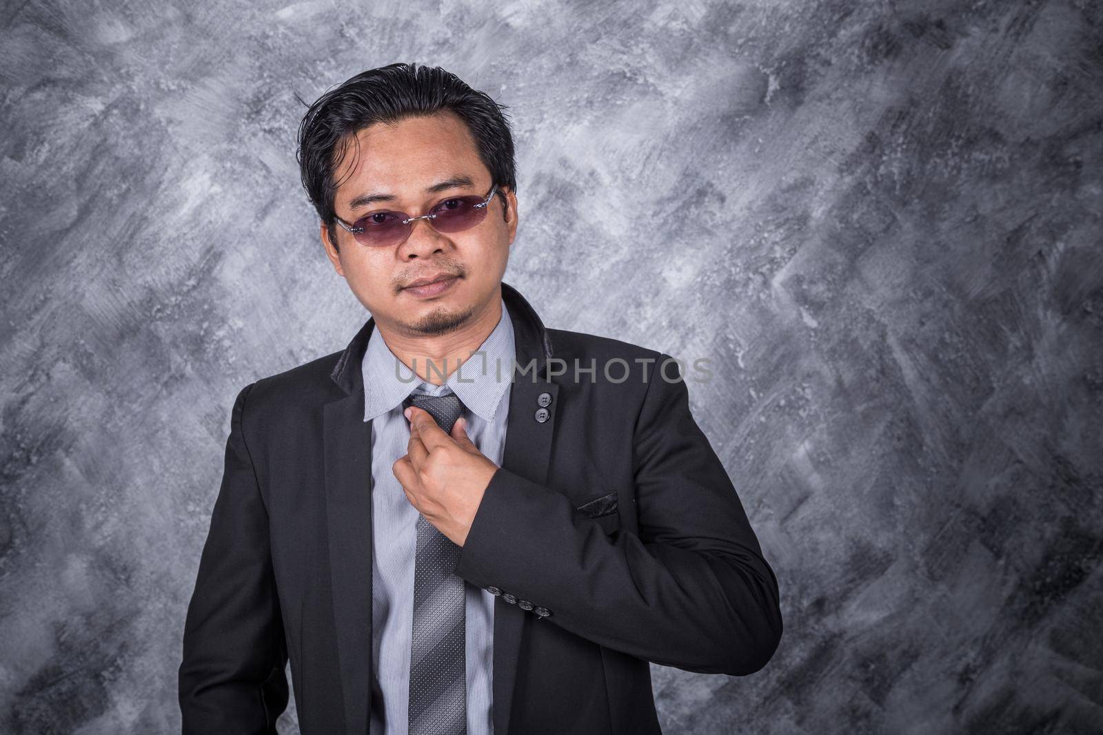 business man in a suit fixing his tie