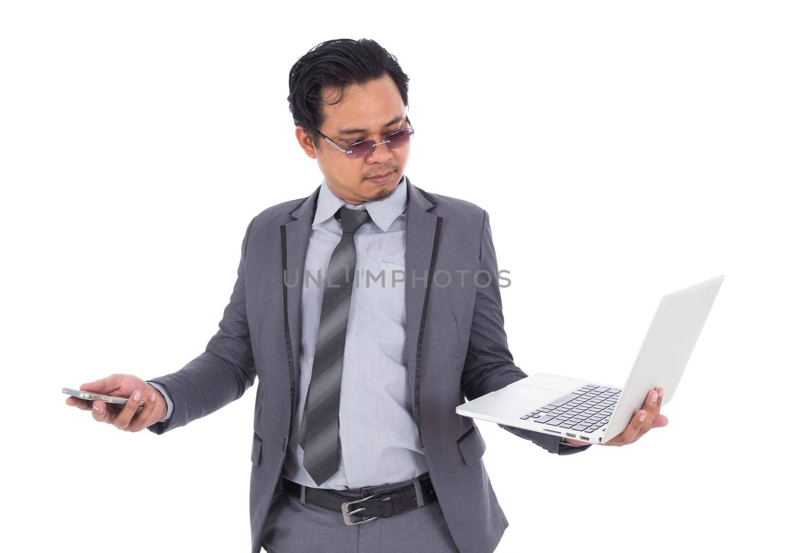 business man holding mobile phone and laptop isolated on white background by geargodz