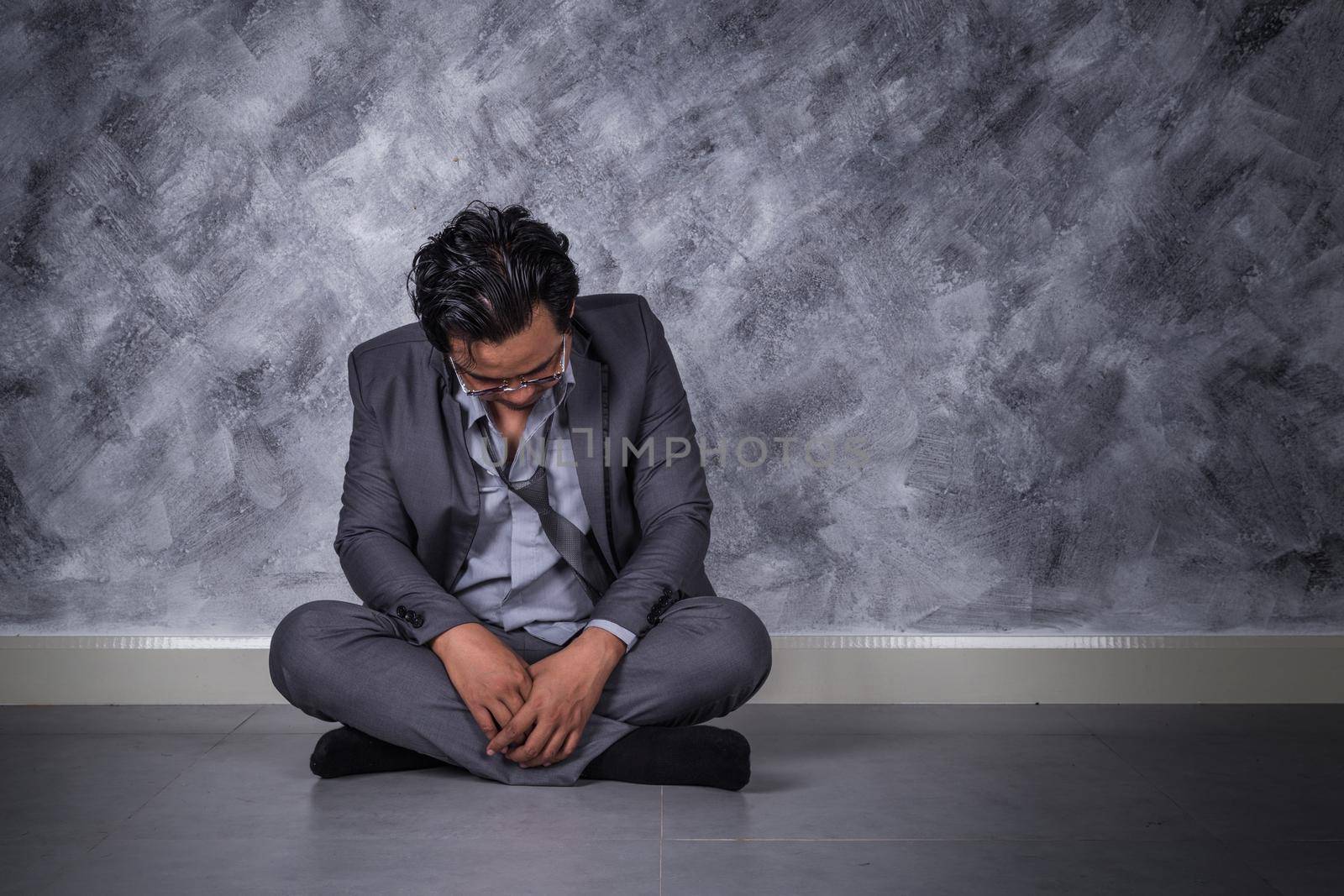 young depressed businessman sitting on the floor