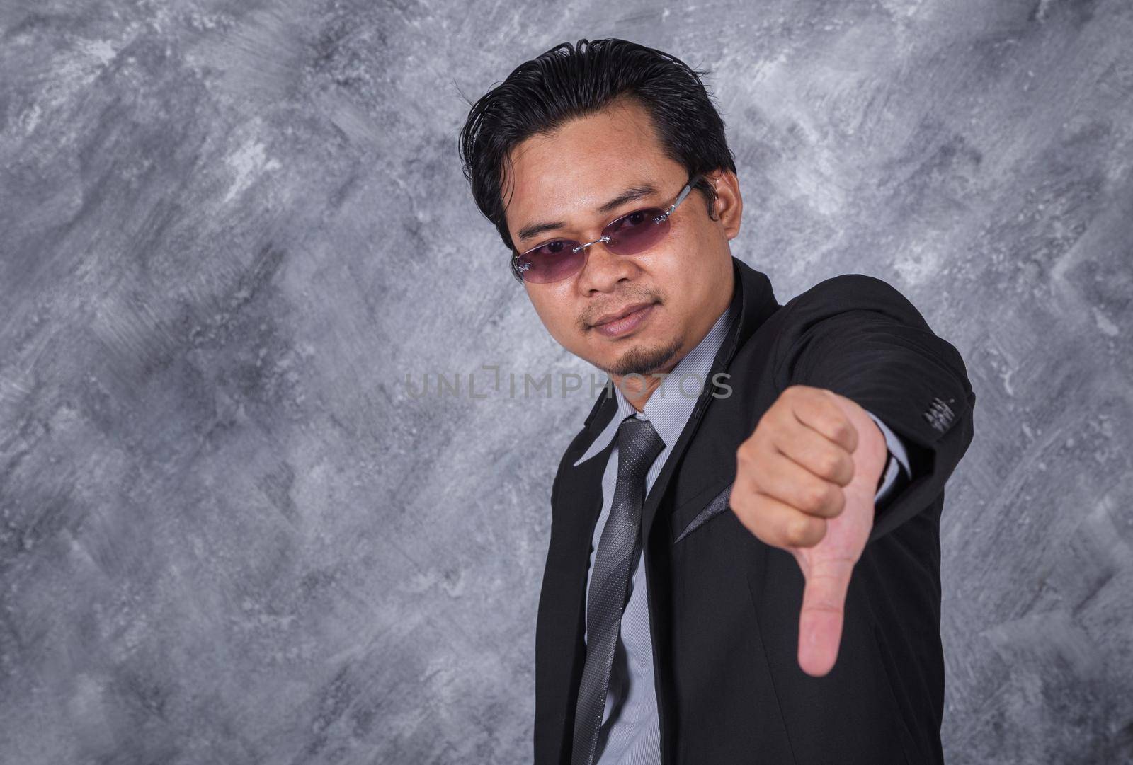 young business man in suit with thumb down 