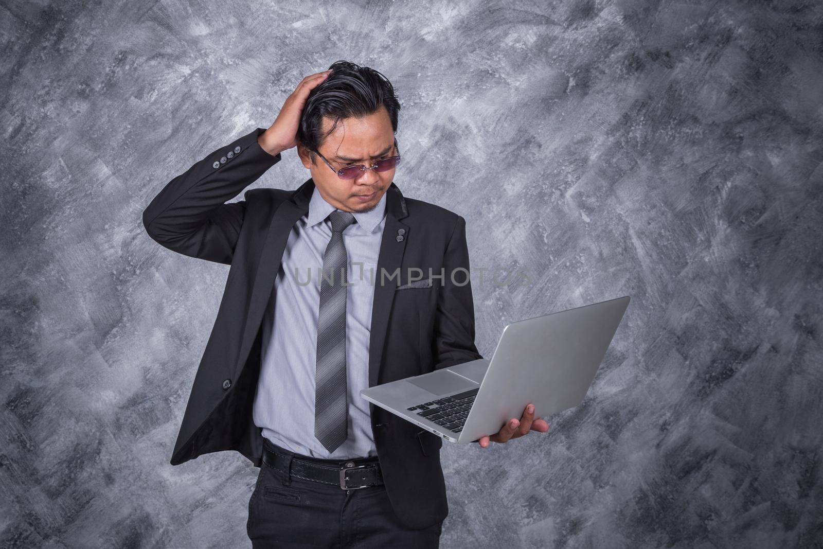 young business man with headache and having problems on laptop