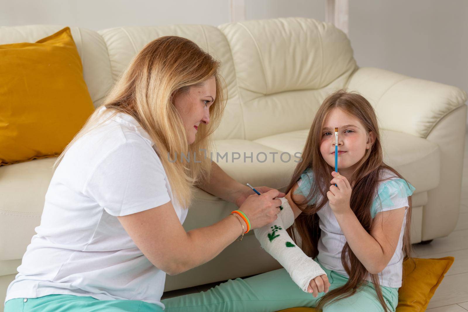 Mother and daughter drawing picture on bandage using paints. Play therapy concept. by Satura86