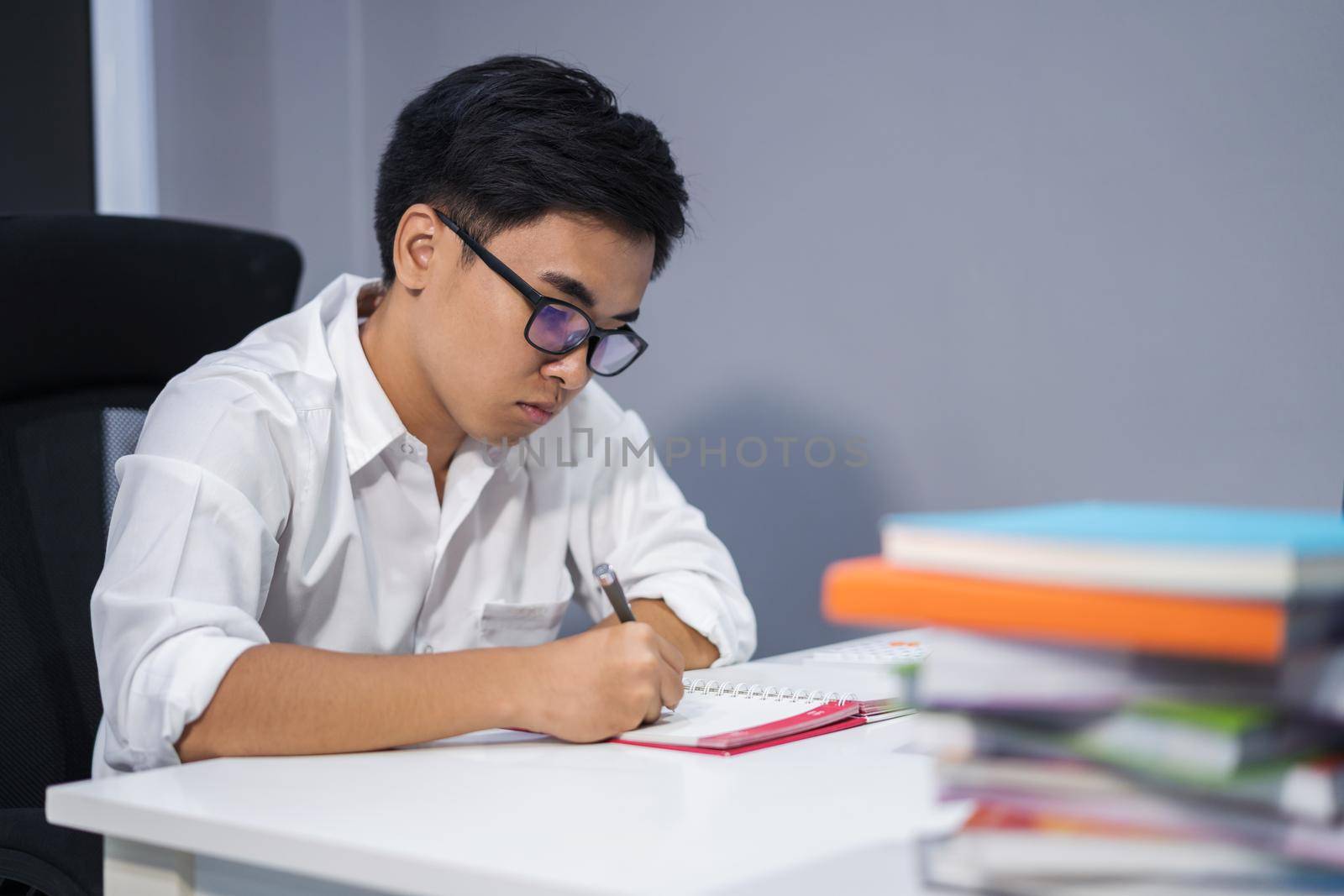 young man studying and writing on notebook 