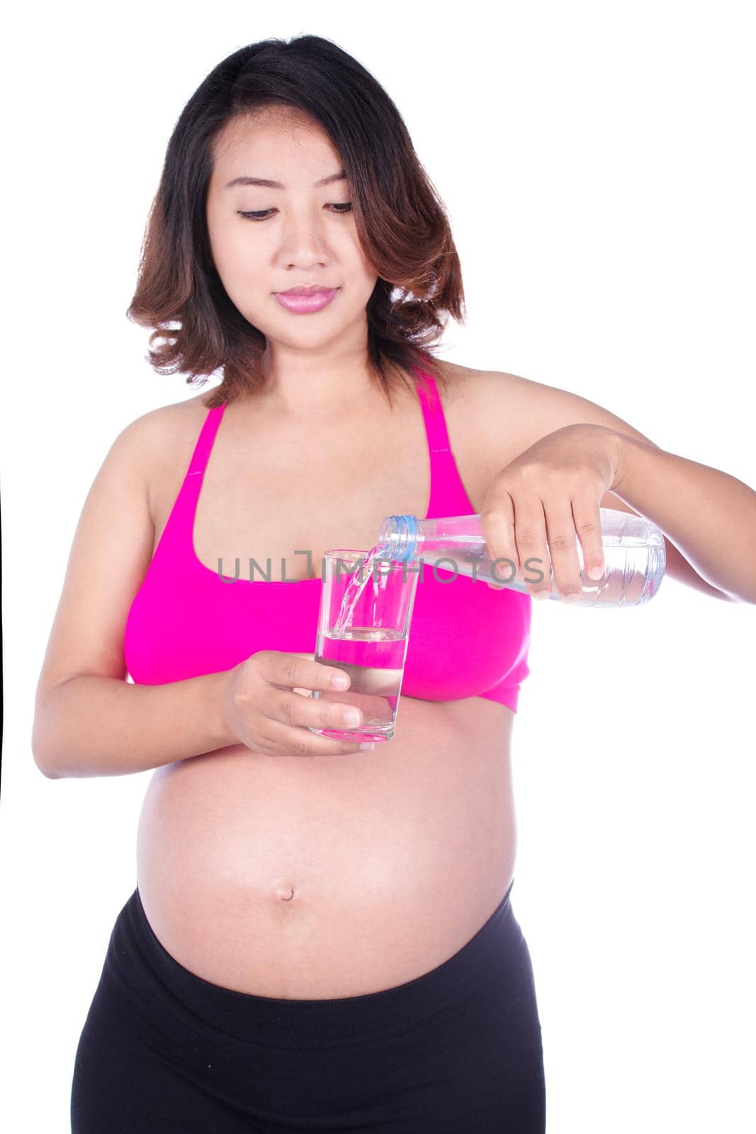 pregnant woman pouring water into a glass isolated on white background