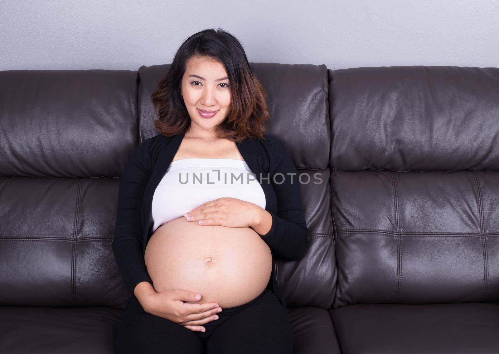 portrait of pregnant woman resting at home on sofa