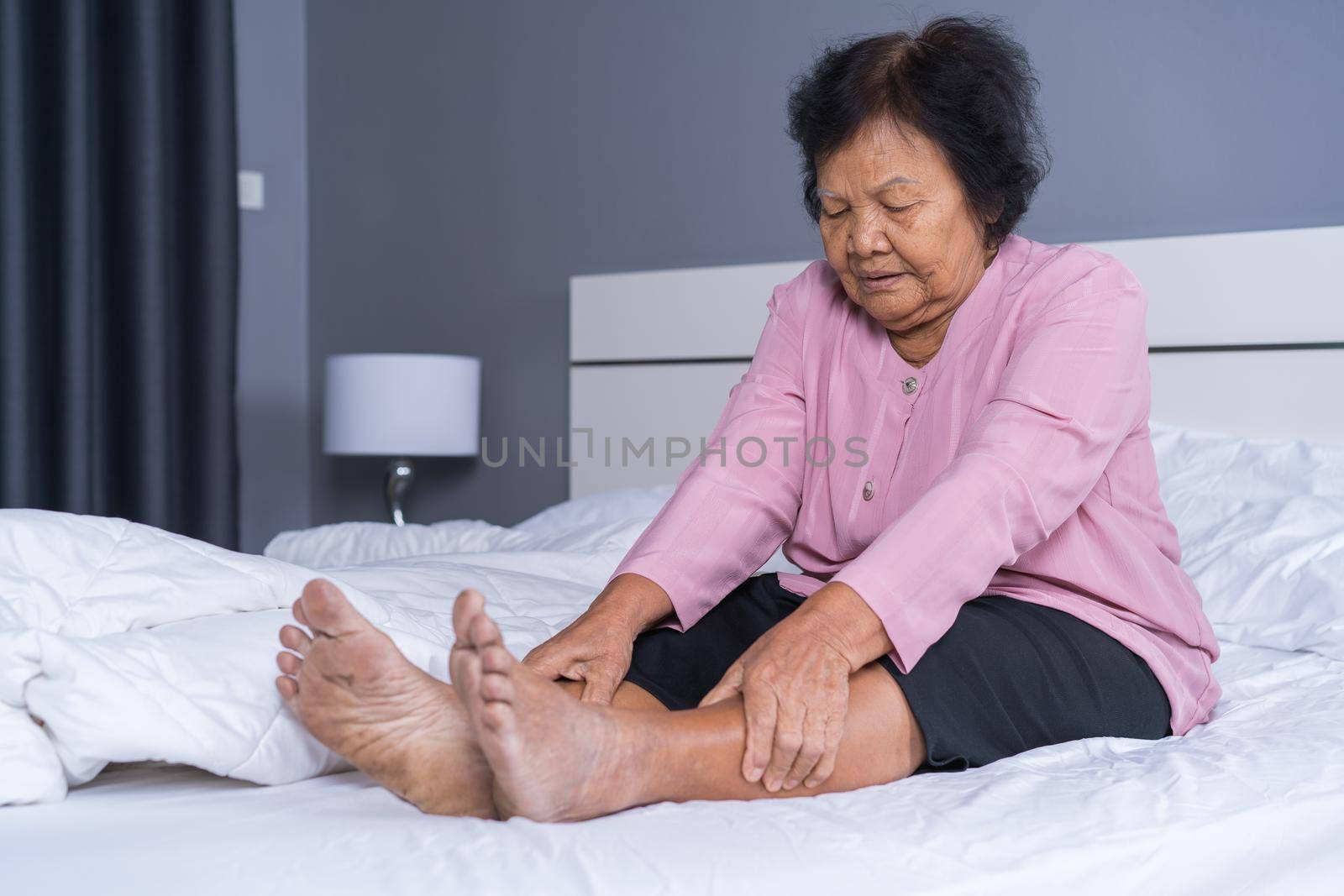 senior woman with leg pain in bed by geargodz