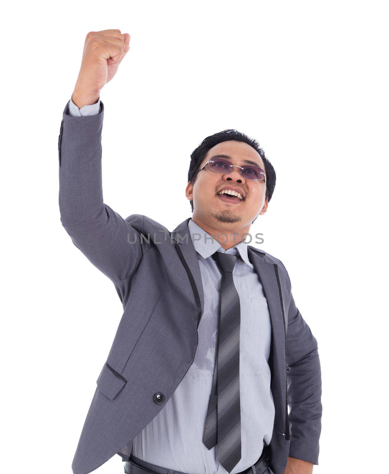 winner business man in suit with arms raised isolated on white background by geargodz