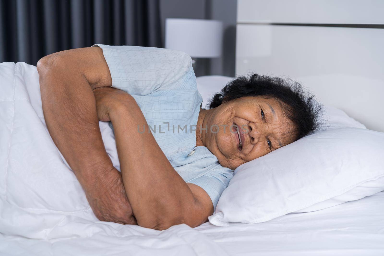 happy senior woman sleeping on a bed