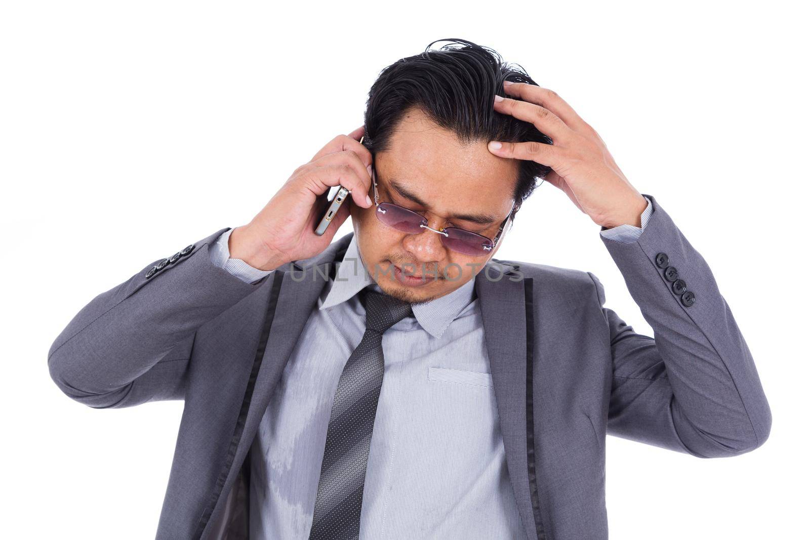 business man receiving bad news on the cell phone isolated on a white background