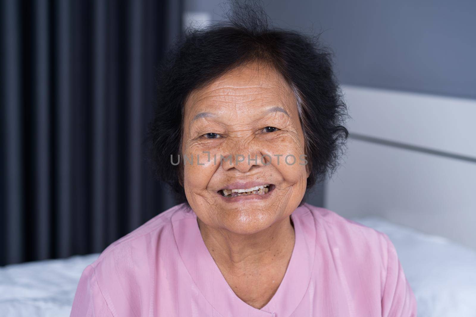 close up of happy smiling senior woman face in bedroom