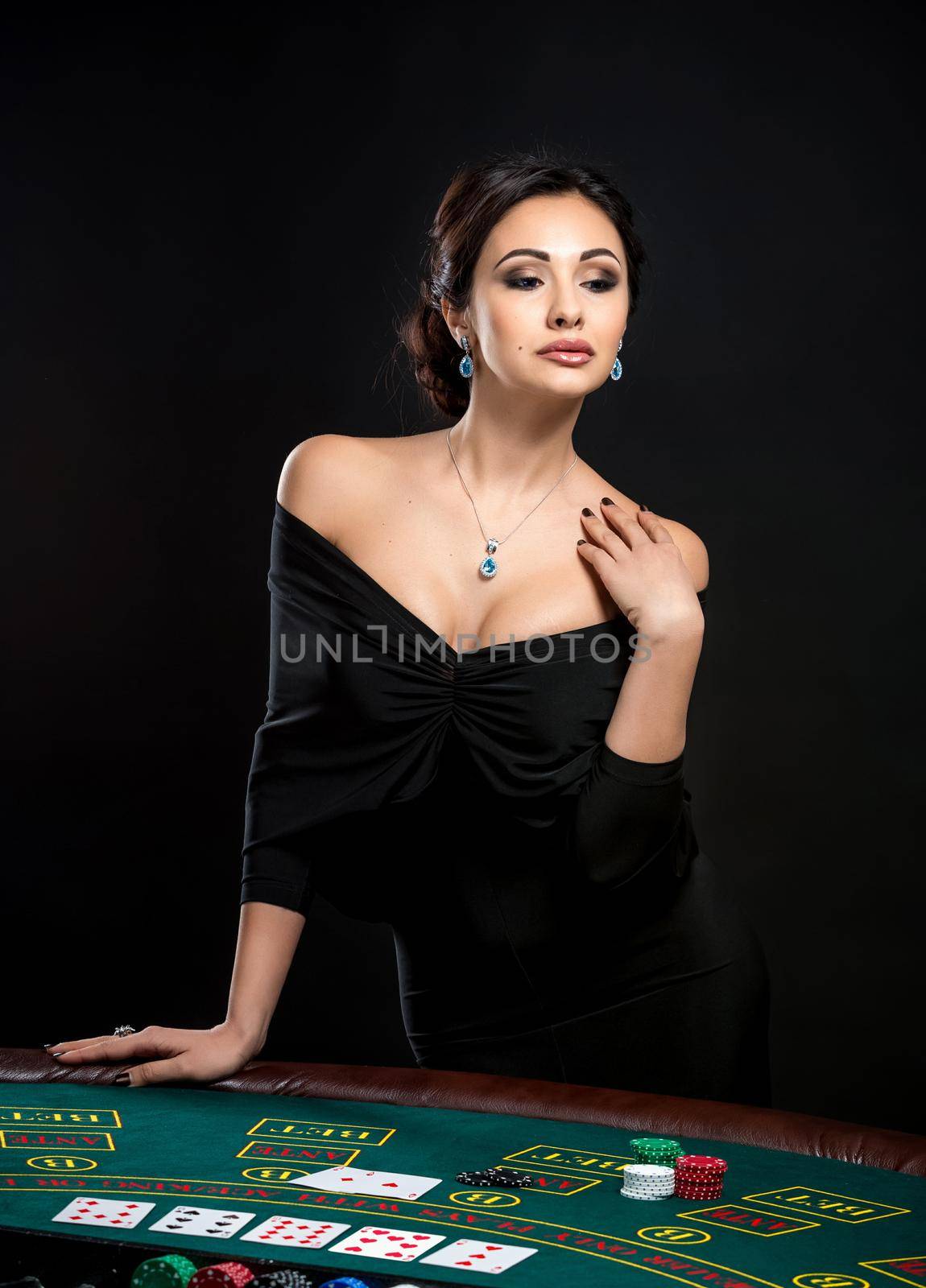 sexy woman with poker cards and chips. Female player in a beautiful black dress