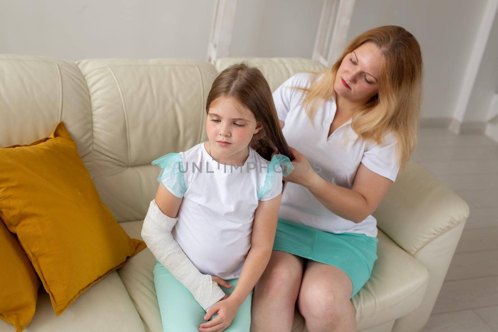 Child with broken arm and gypsum spend time at home with mother. Childhood illnesses, a positive outlook and recovery. by Satura86