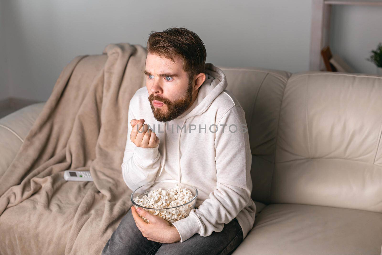 Man watching movies lying on a couch at home