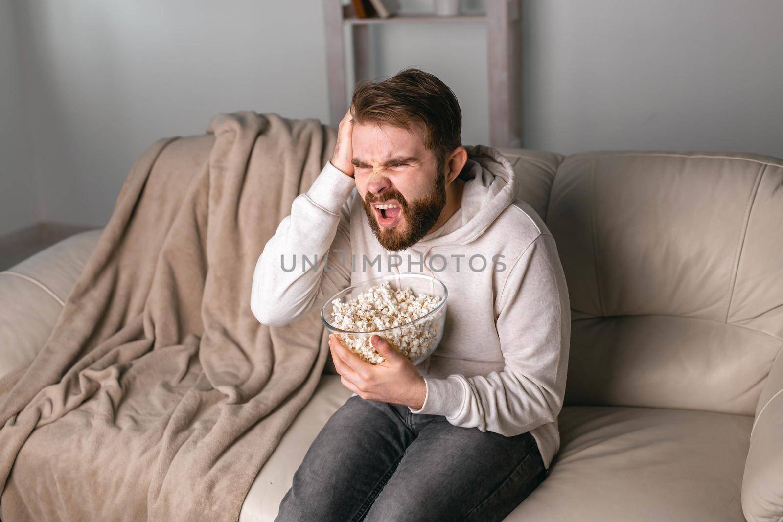 Beard man holding his head and watch sports match and do not understand how his team could lose. Concept of sports game winner and loser